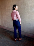 Woman wearing premium lightweight cotton poplin Maisey Blouse by Trovata with long sleeves and v-neck in pink and white tiny Houndstooth print