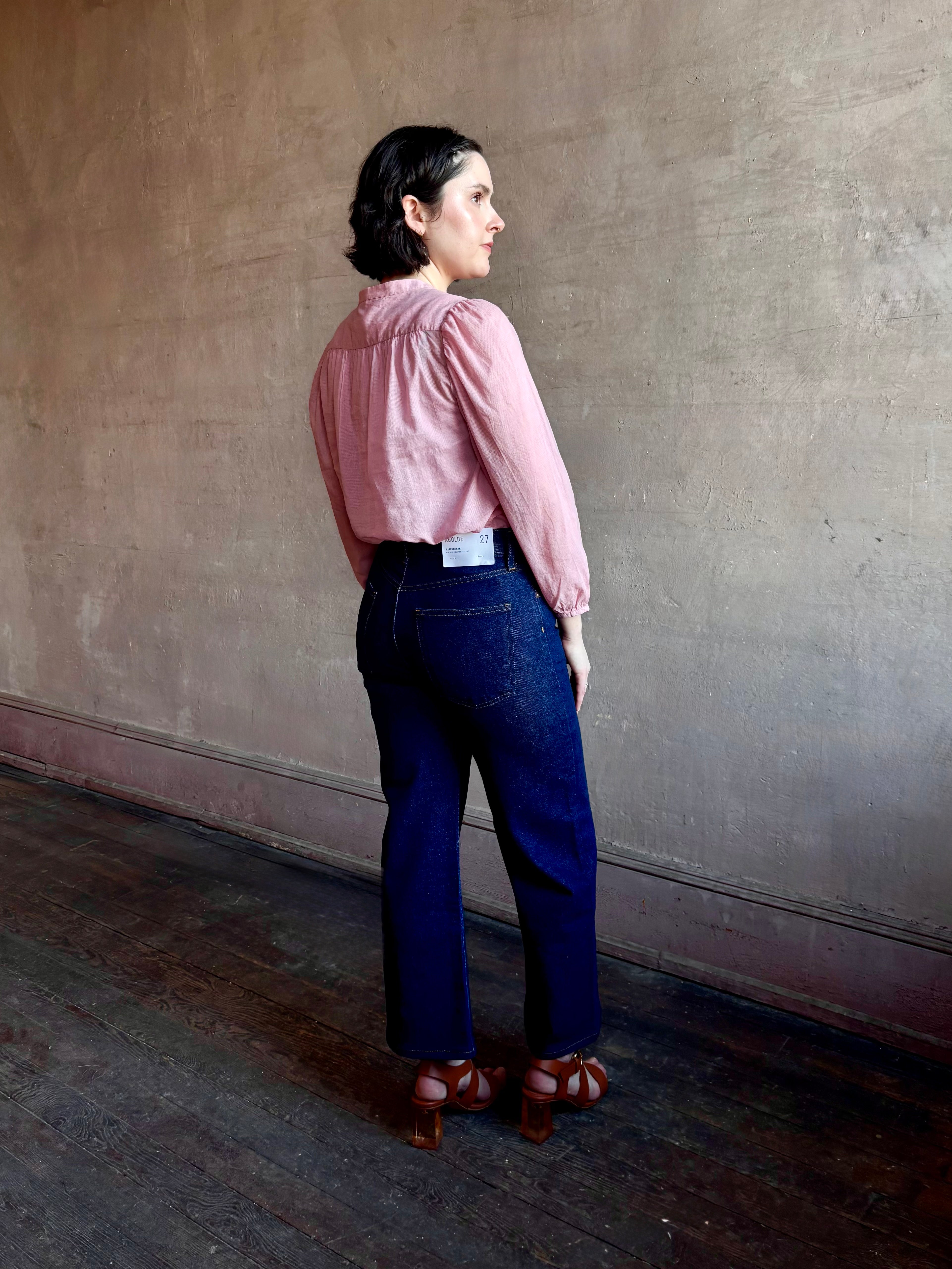 Woman wearing premium lightweight cotton poplin Maisey Blouse by Trovata with long sleeves and v-neck in pink and white tiny Houndstooth print