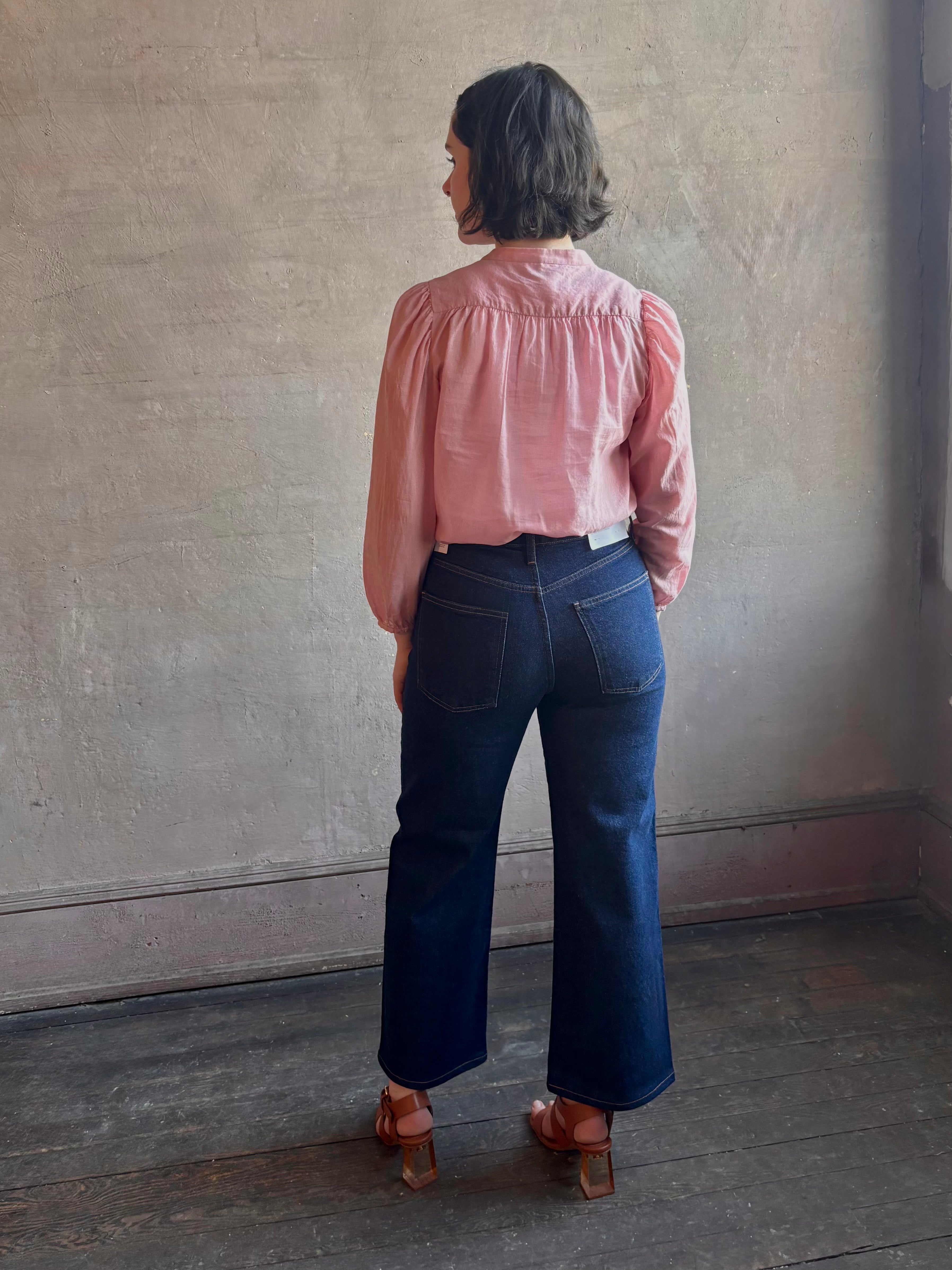 Woman wearing premium lightweight cotton poplin Maisey Blouse by Trovata with long sleeves and v-neck in pink and white tiny Houndstooth print
