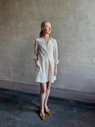 Woman wearing elevated casual wear Trovata Marina cotton shirt Dress in cream and red Stripe with mandarin collar, long sleeves, pockets and expert tailoring