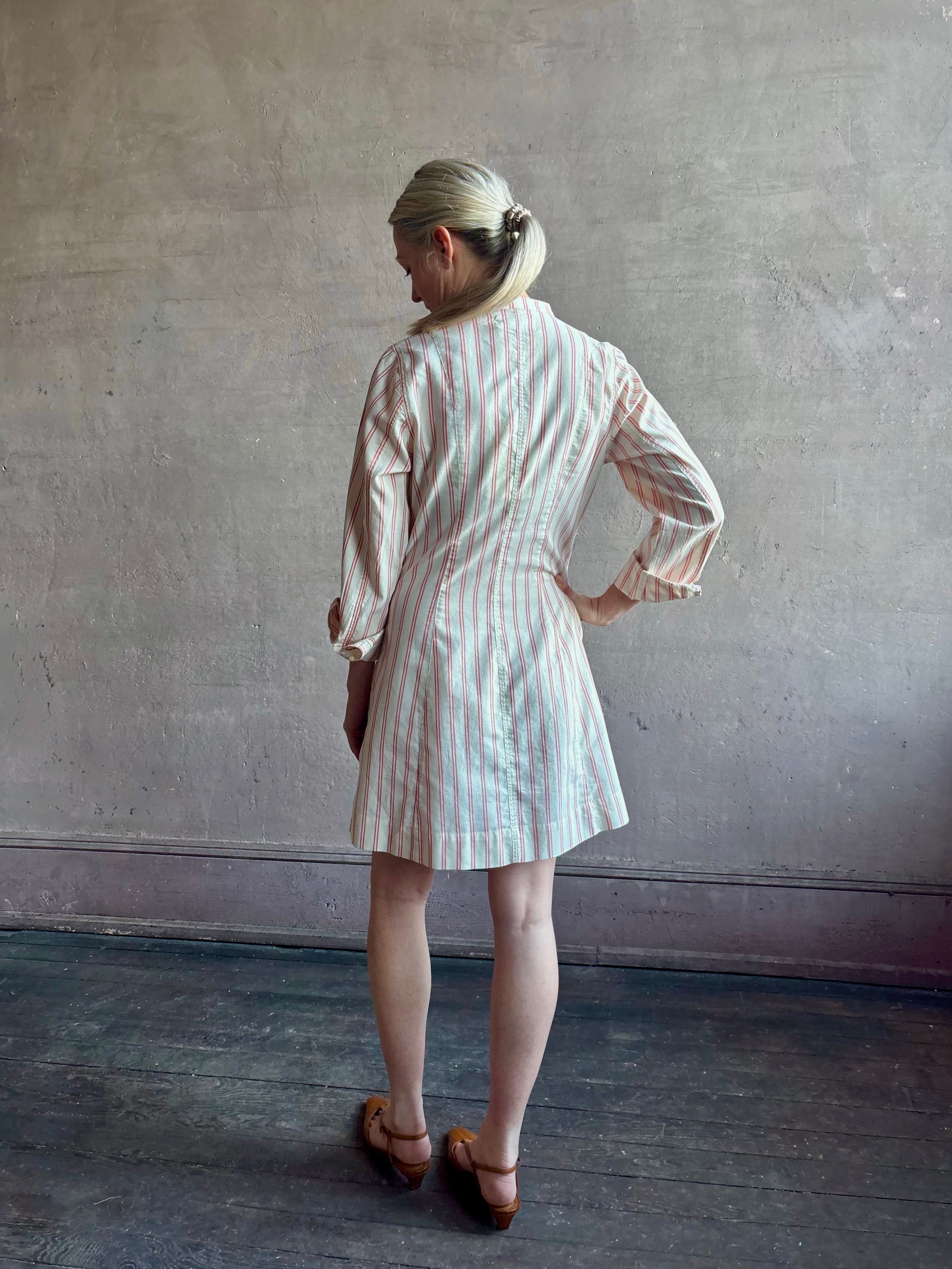 Woman wearing elevated casual wear Trovata Marina cotton shirt Dress in cream and red Stripe with mandarin collar, long sleeves and pockets