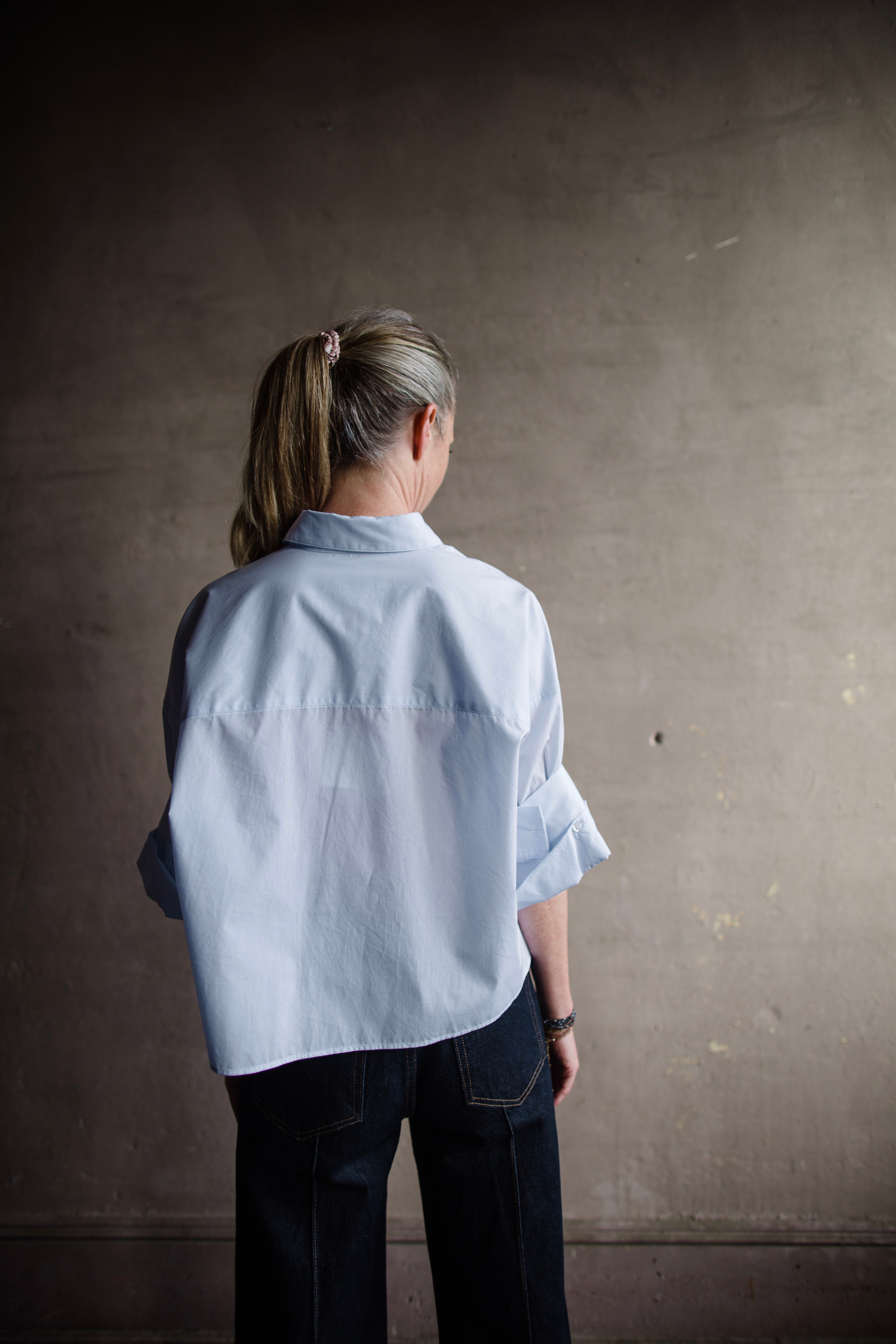 Image featuring a woman wearing TWP next ex shirt in baby blue color fabricated from 100% superfine cotton.