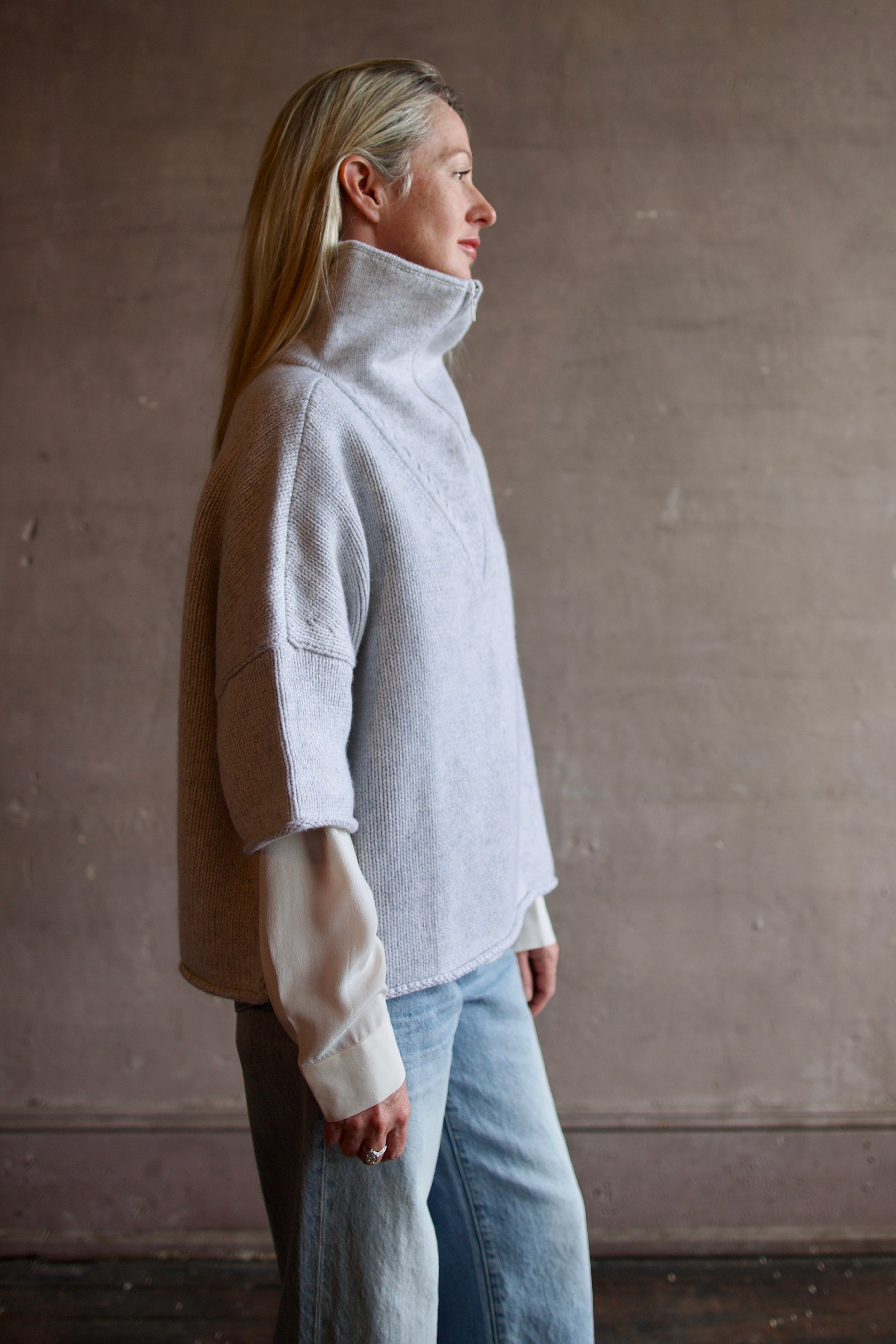 Model wearing a light gray layering cashmere sweater with 3/4 zip by American designer TWP