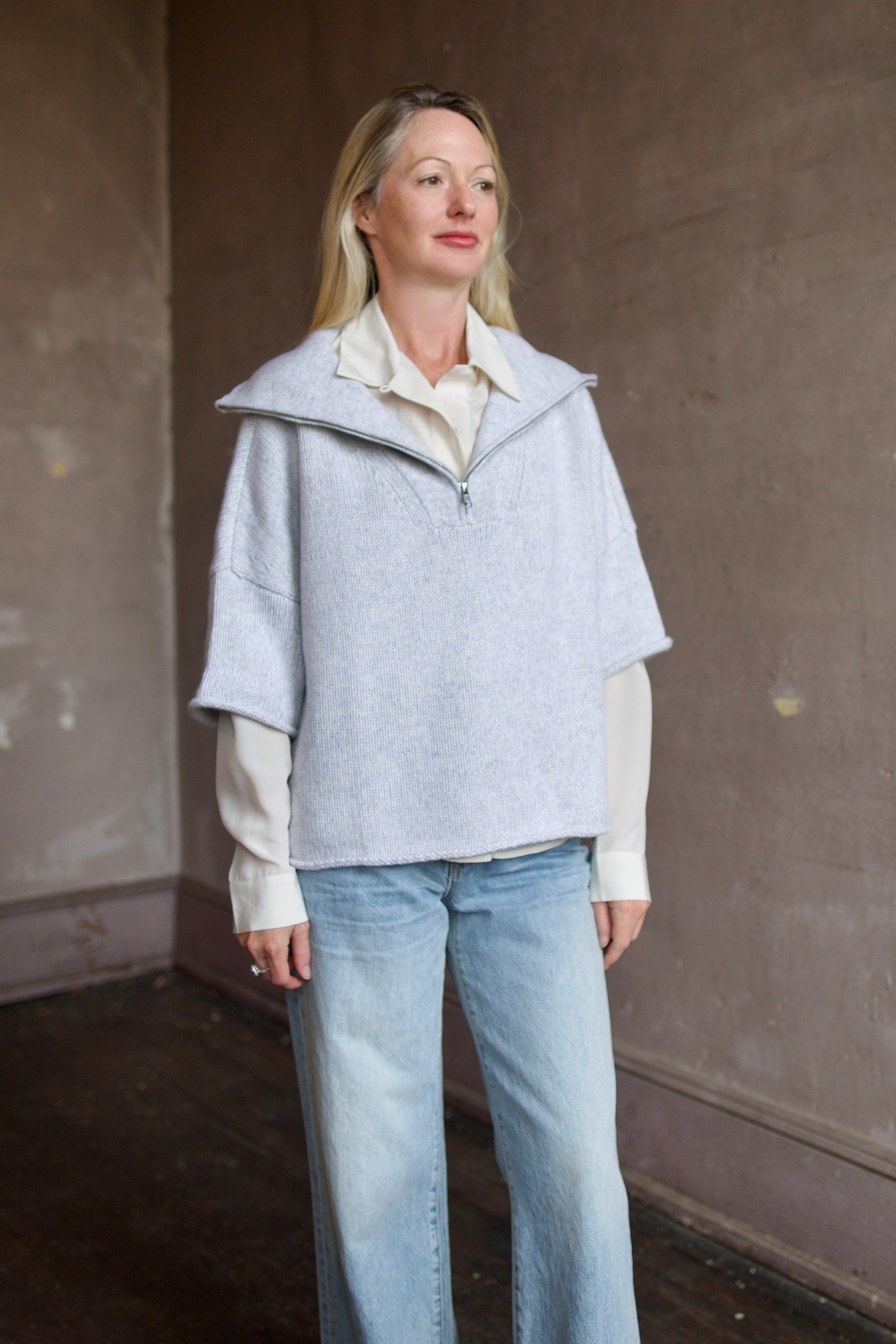 Mature model wearing a light gray layering cashmere sweater with 3/4 zip by American designer TWP
