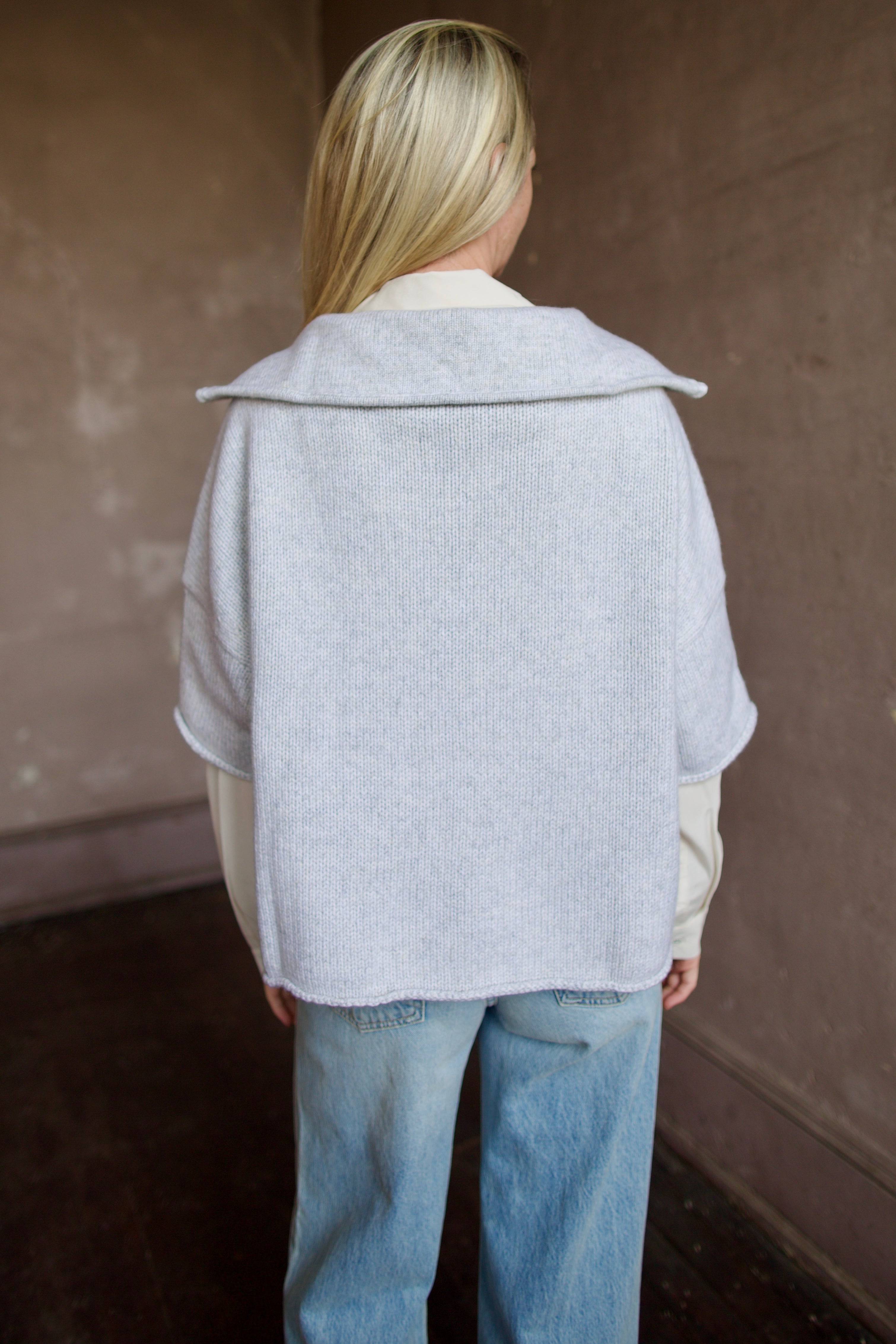 Mature model wearing a light gray layering cashmere sweater with 3/4 zip by American designer TWP