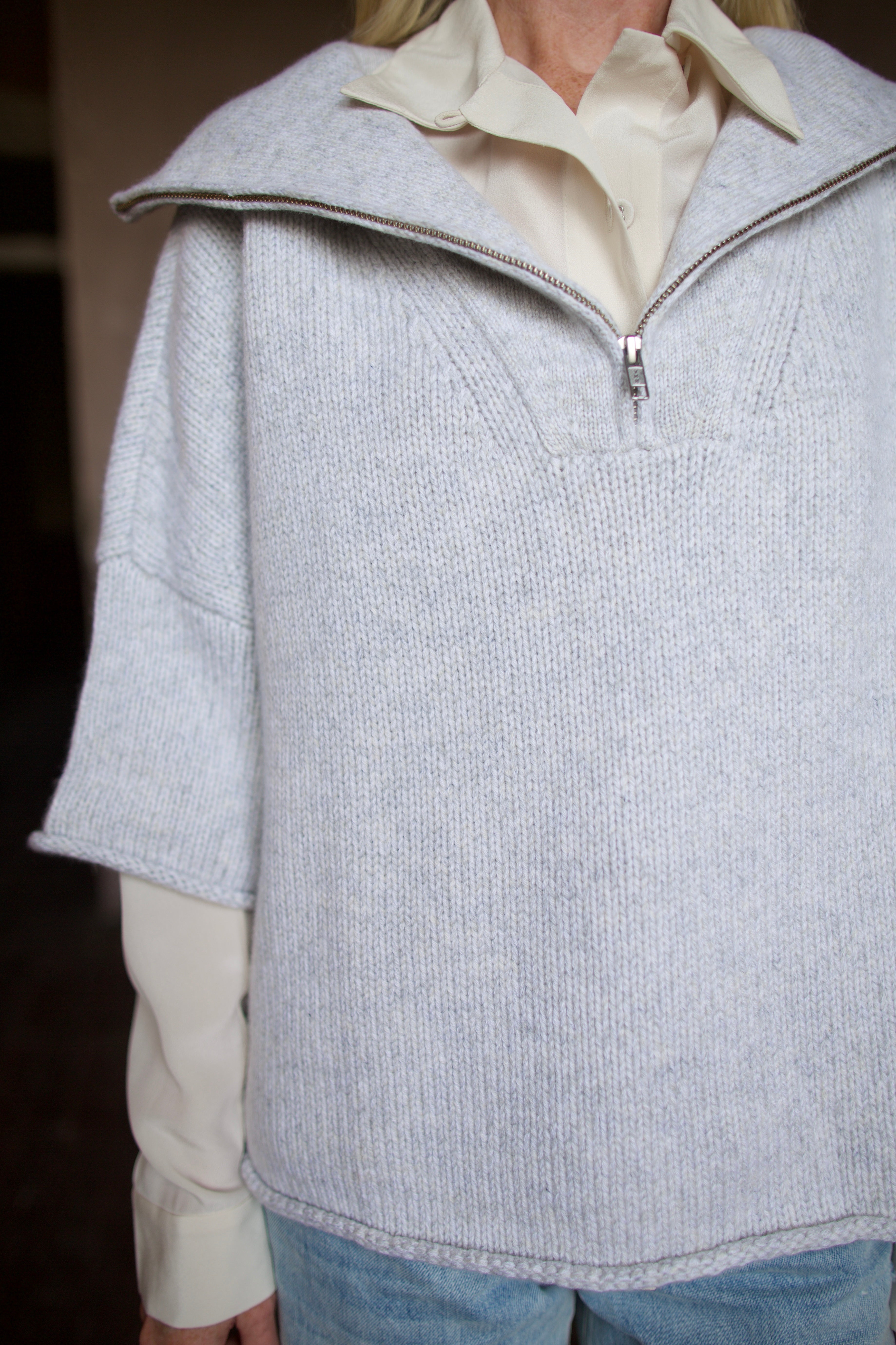Mature model wearing a light gray layering cashmere sweater with 3/4 zip by American designer TWP