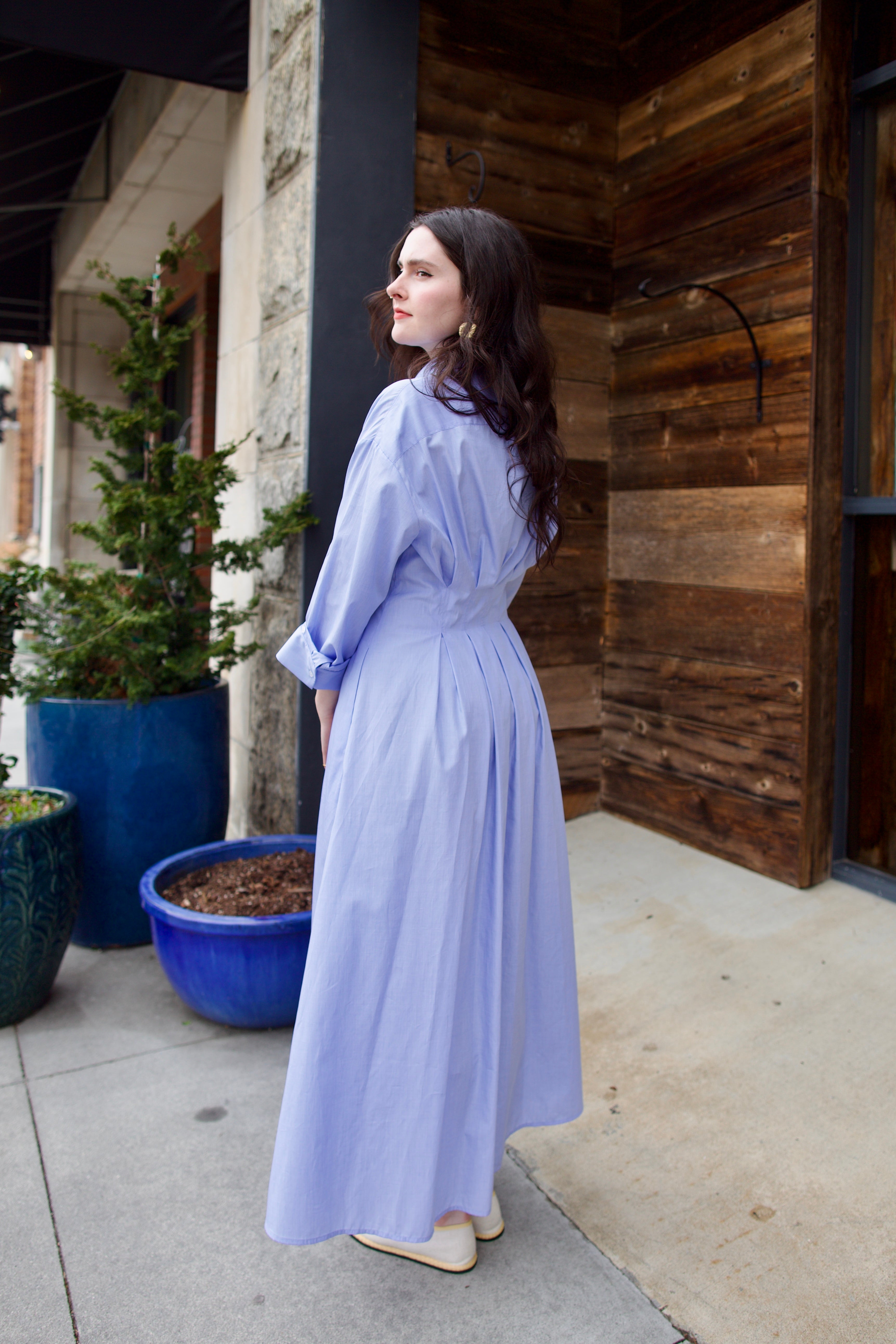 Image of woman wearing TWP M Dress, luxury women's superfine cotton dress featuring button-front closure with pleats and midi hem in blue