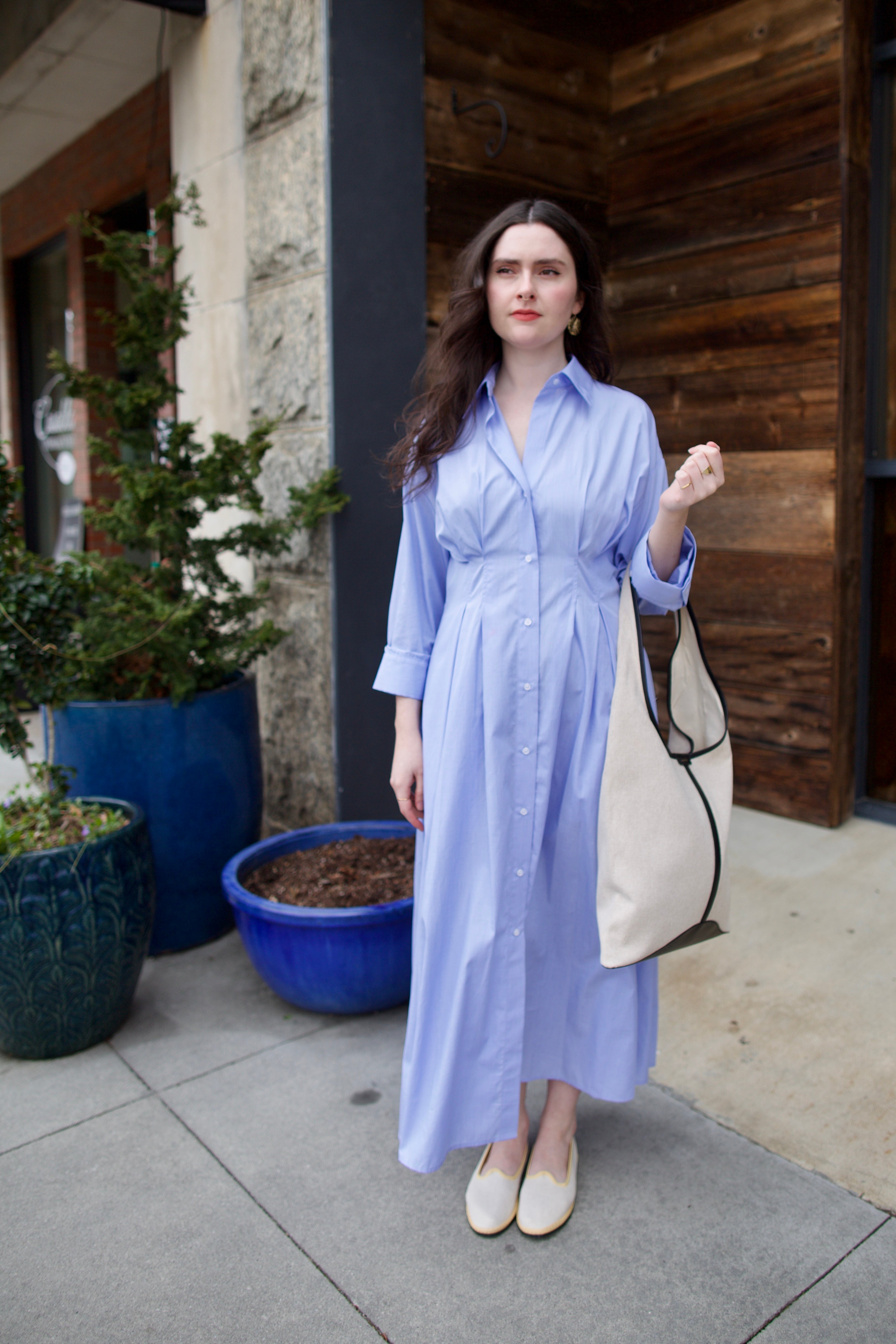 Image of woman wearing TWP M Dress, luxury women's superfine cotton dress featuring button-front closure with pleats and midi hem in blue