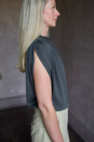 Mature model wearing a rich green TWP silk blouse with waterfall front  and modern asymmetrical design