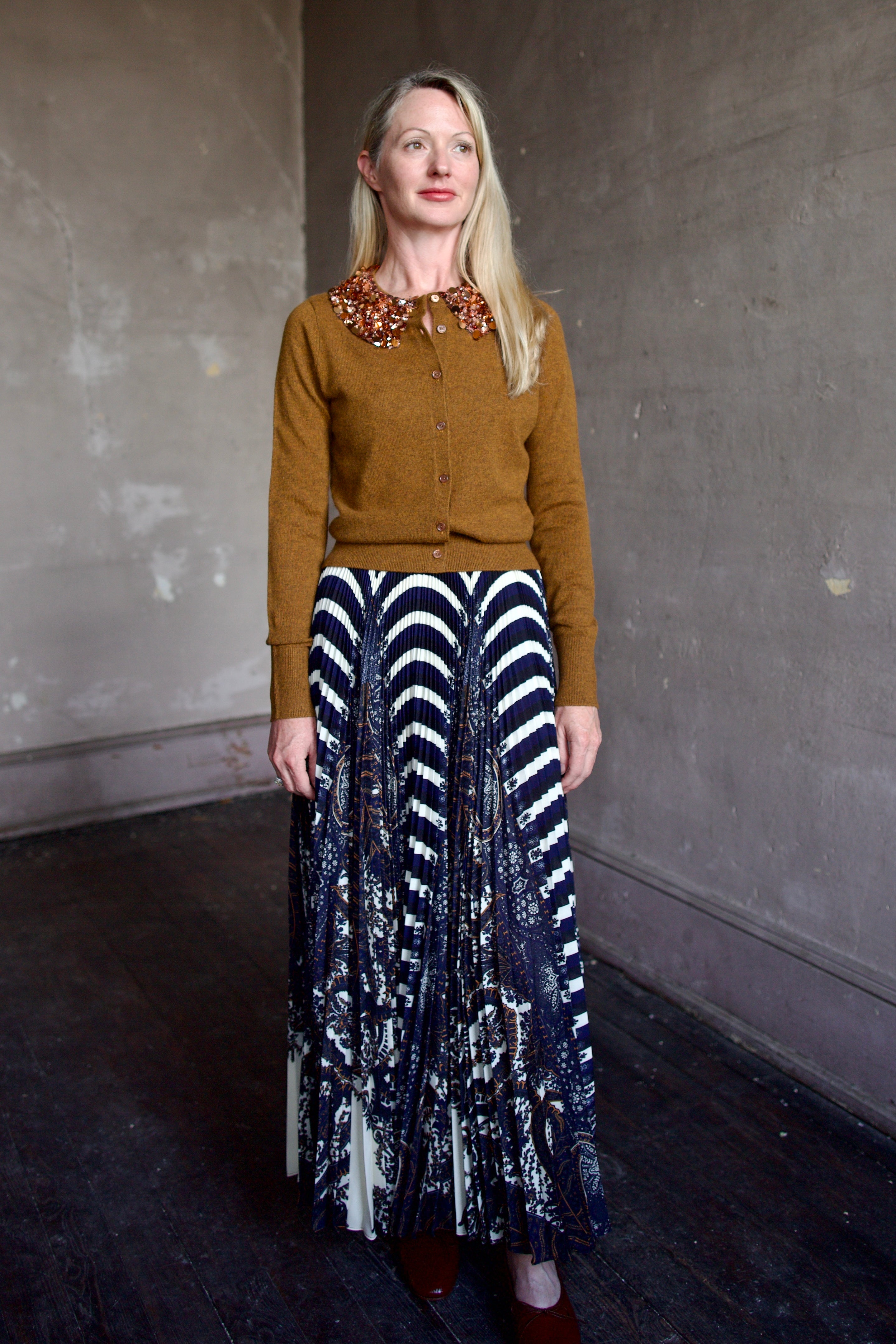 Mature model wearing a brown cashmere cardigan with a sequin embellished collar by Ulla Johnson