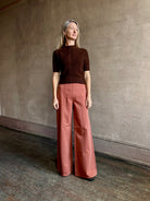 Woman wearing ULLA JOHNSON Bianca faded red rigid Jean with flat front and front seam details down leg panels