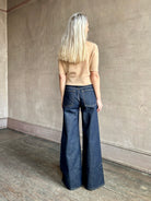 Woman wearing ULLA JOHNSON Bianca dark wash rigid Jean with back pockets and leather Ulla tag