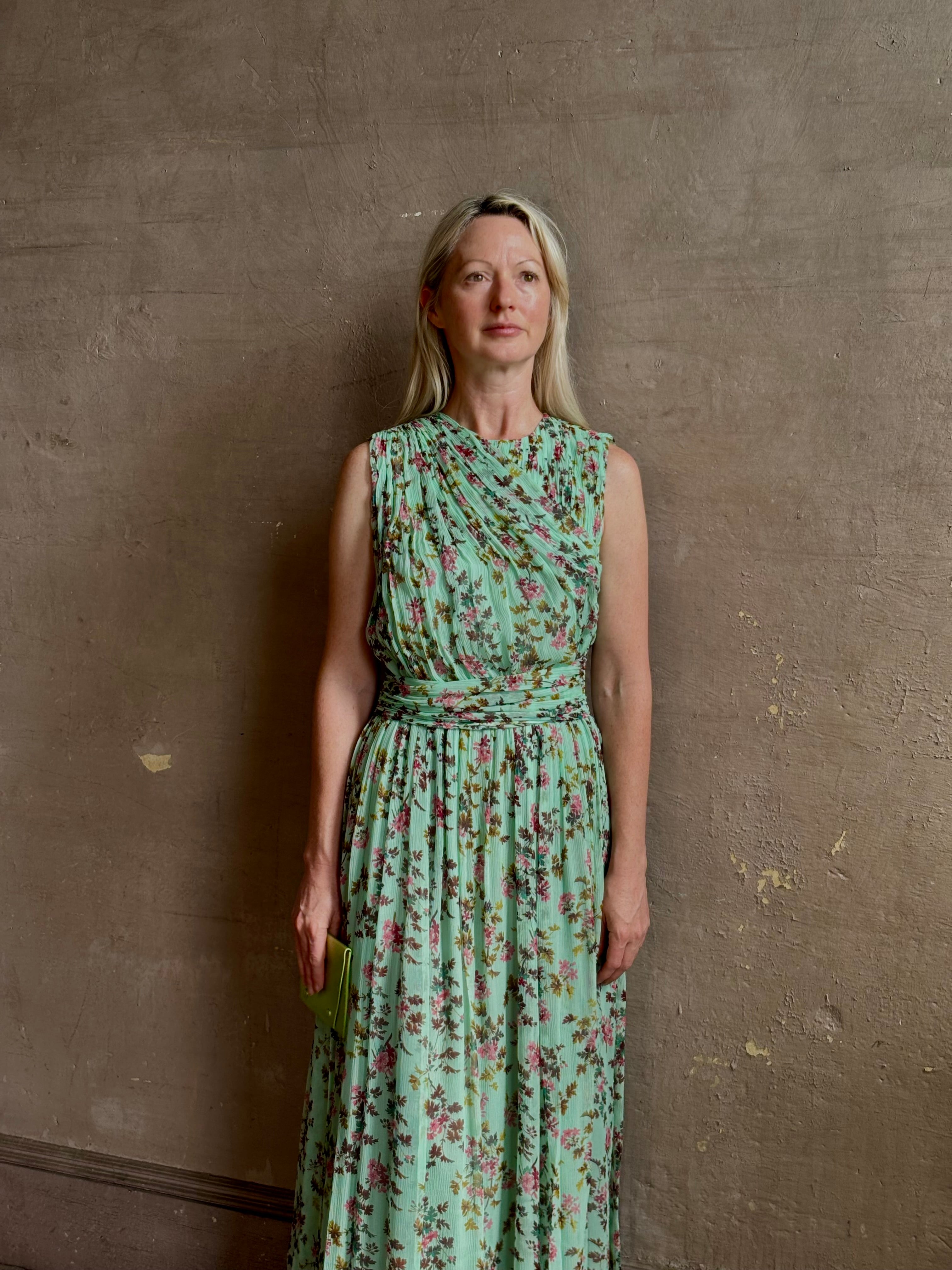 Mature woman wearing  women's designer celestina silk maxi dress rendered in a mint green ground adorned with delicate brown and pink florals from Ulla Johnson that is sleevesless with gathered fabric bodice and waistband