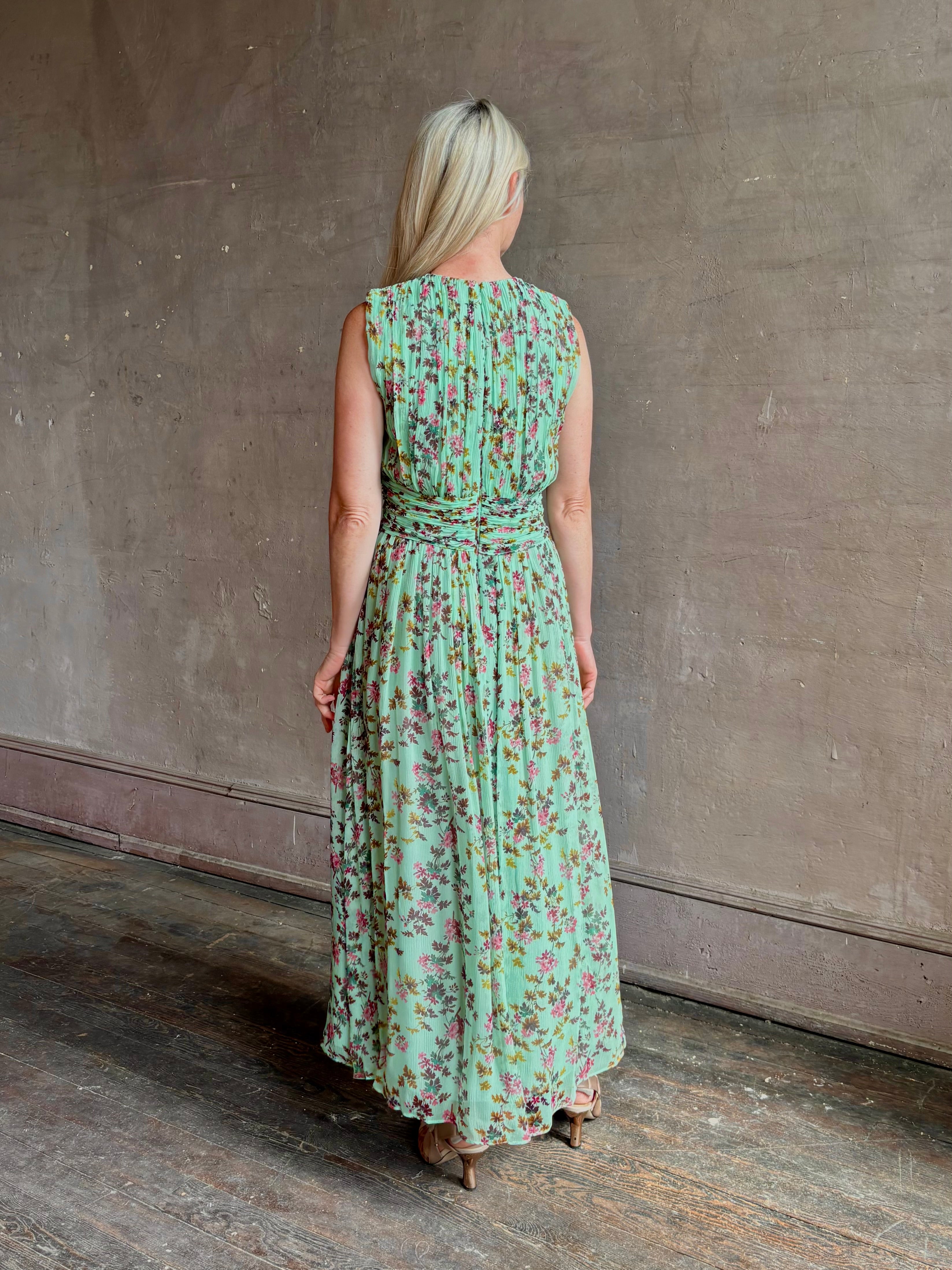 Mature woman wearing  women's designer celestina silk maxi dress rendered in a mint green ground adorned with delicate brown and pink florals from Ulla Johnson that is sleevesless with gathered fabric bodice and waistband