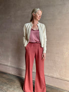 Mature woman wearing the Delphina Long Sleeve Cardigan from Ulla Johnson rendered in a soft off-white  with crew neck, feminine sleeves and button front