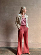 Mature woman wearing the Delphina Long Sleeve Cardigan from Ulla Johnson rendered in a soft off-white  with crew neck, feminine sleeves and button front