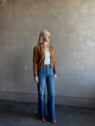 Mature woman wearing the Delphina Long Sleeve women's designer Cardigan from Ulla Johnson rendered in an umber hue with a crew neck and button front