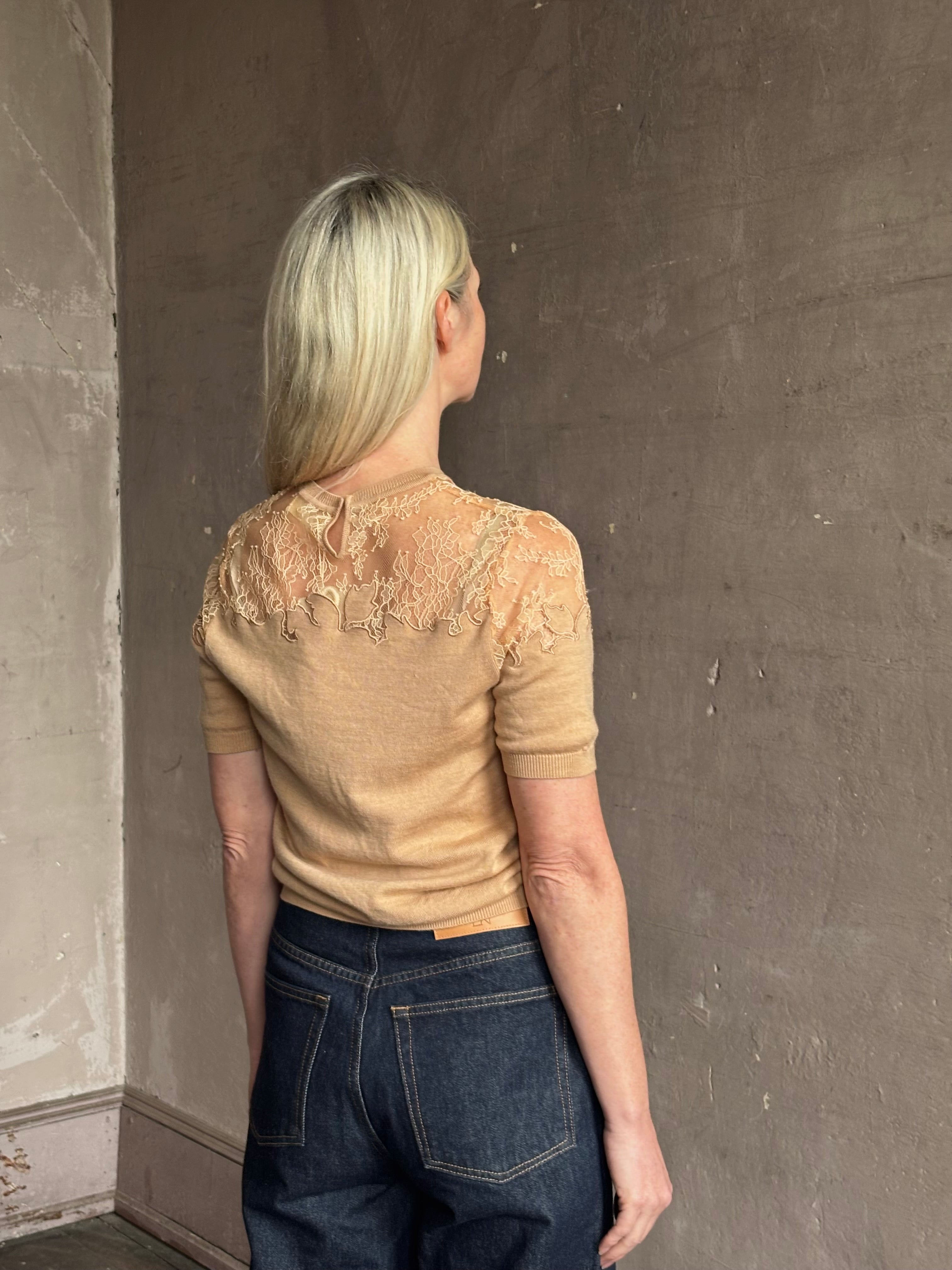 Mature woman wearing Ulla Johnson's Ella Short Sleeve Lace merino wool knit Top in Almond delicate lace detailing at the shoulders timeless elegance