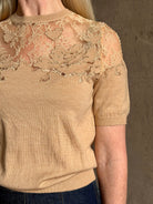 Mature woman wearing Ulla Johnson's Ella Short Sleeve Lace merino wool knit Top in Almond delicate lace detailing at the shoulders classic elegance