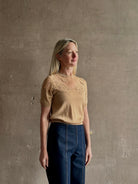 Mature woman wearing Ulla Johnson's Ella Short Sleeve Lace merino wool knit Top in Almond delicate lace detailing at the shoulders Romantic artistic elegance