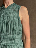 Woman wearing Freesia Gown from Ulla Johnson rendered in a soft green and crafted from luxurious silk crinkle chiffon with low back and flexible waistband