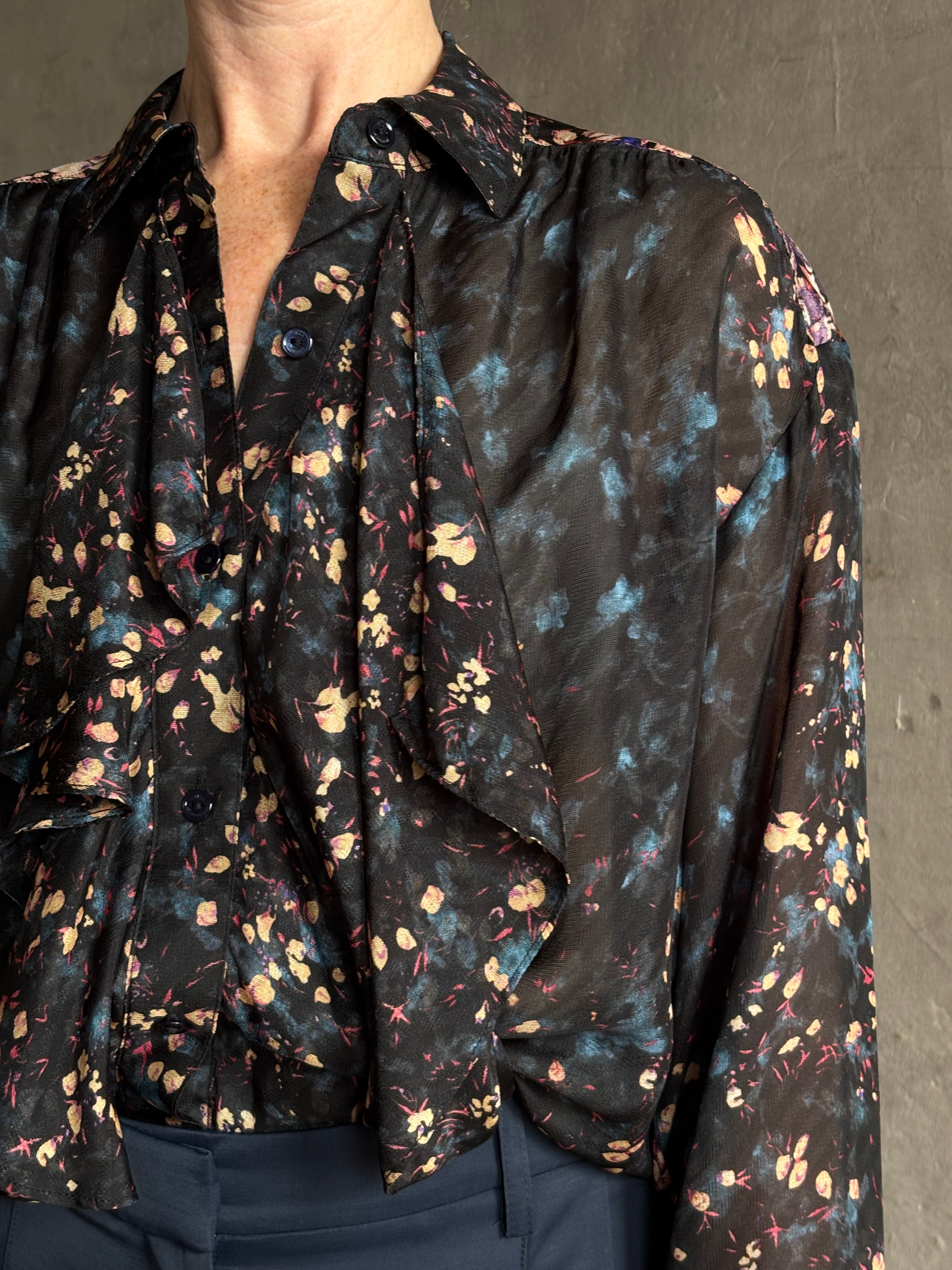 woman wearing designer Ulla Johnson long-sleeve black silk blouse subtle floral print collared button front ruffle