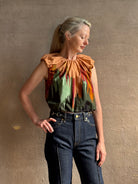 Mature woman wearing Women's designer Gracie sleeveless Cotton Top from Ulla Johnson rendered in a rich abstract Agate print composed of dark green, mint green, burgundy, terra cotta, and sienna and crafted from lightweight cotton poplin