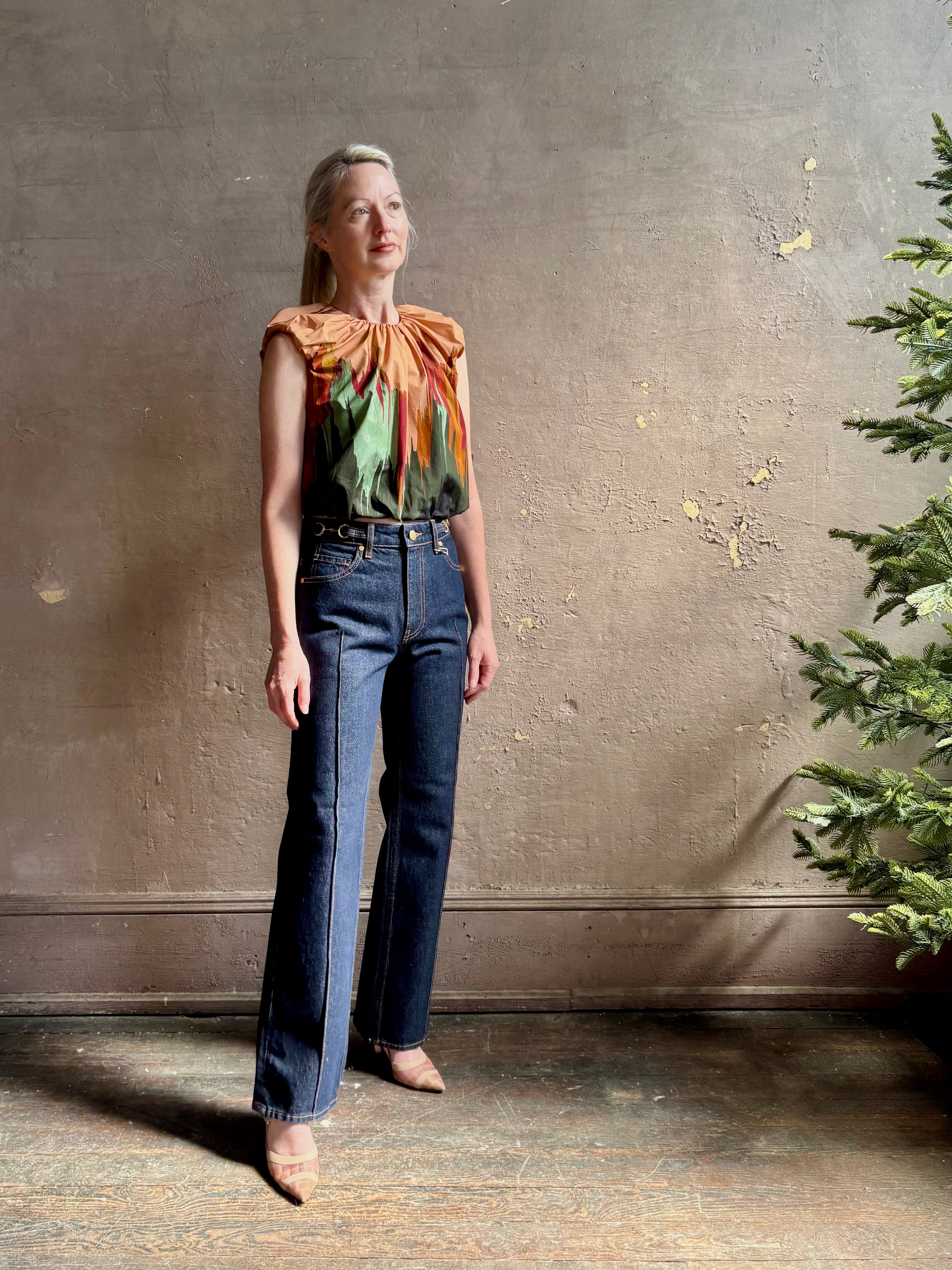 Mature woman wearing Women's designer Gracie sleeveless Cotton Top from Ulla Johnson rendered in a rich abstract Agate print composed of dark green, mint green, burgundy, terra cotta, and sienna and crafted from lightweight cotton poplin