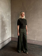 Mature woman wearing designer Ulla Johnson Imara Short Sleeve dark green Sweater with a dimensional open weave
