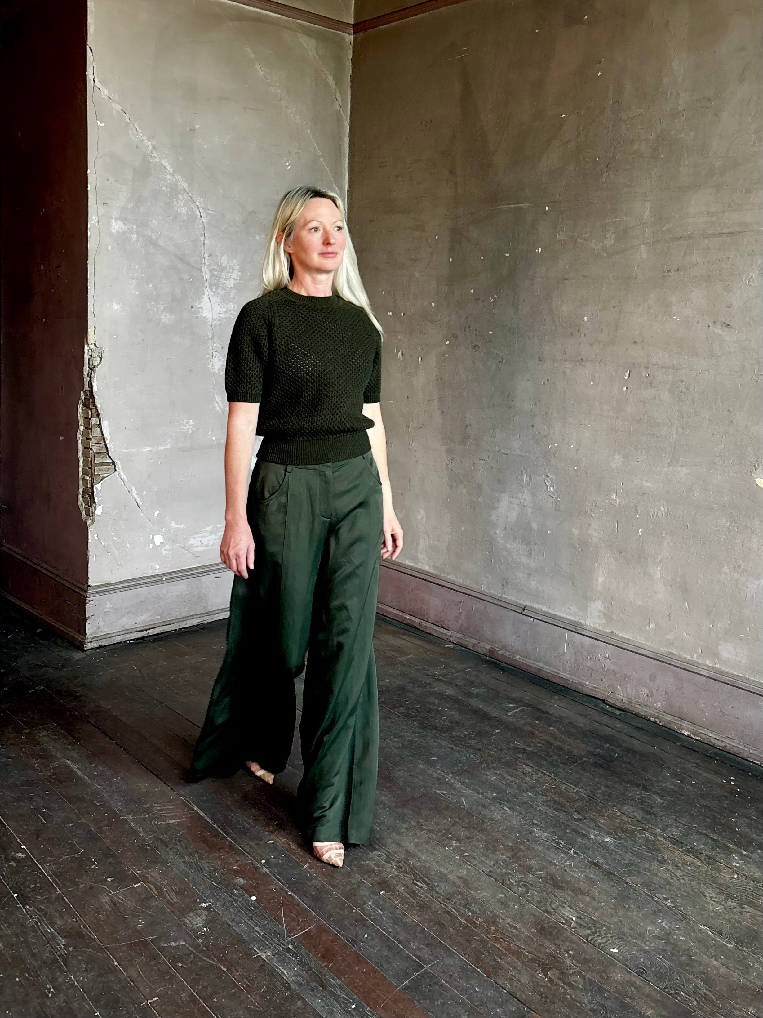 Mature woman wearing designer Ulla Johnson Imara Short Sleeve dark green Sweater with a dimensional open weave