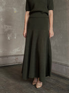 Mature woman wearing designer Ulla Johnson Lucia Wool dark green open Knit maxi Skirt with stretch waistband