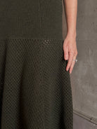 Mature woman wearing designer Ulla Johnson Lucia Wool dark green open Knit maxi Skirt with stretch waistband