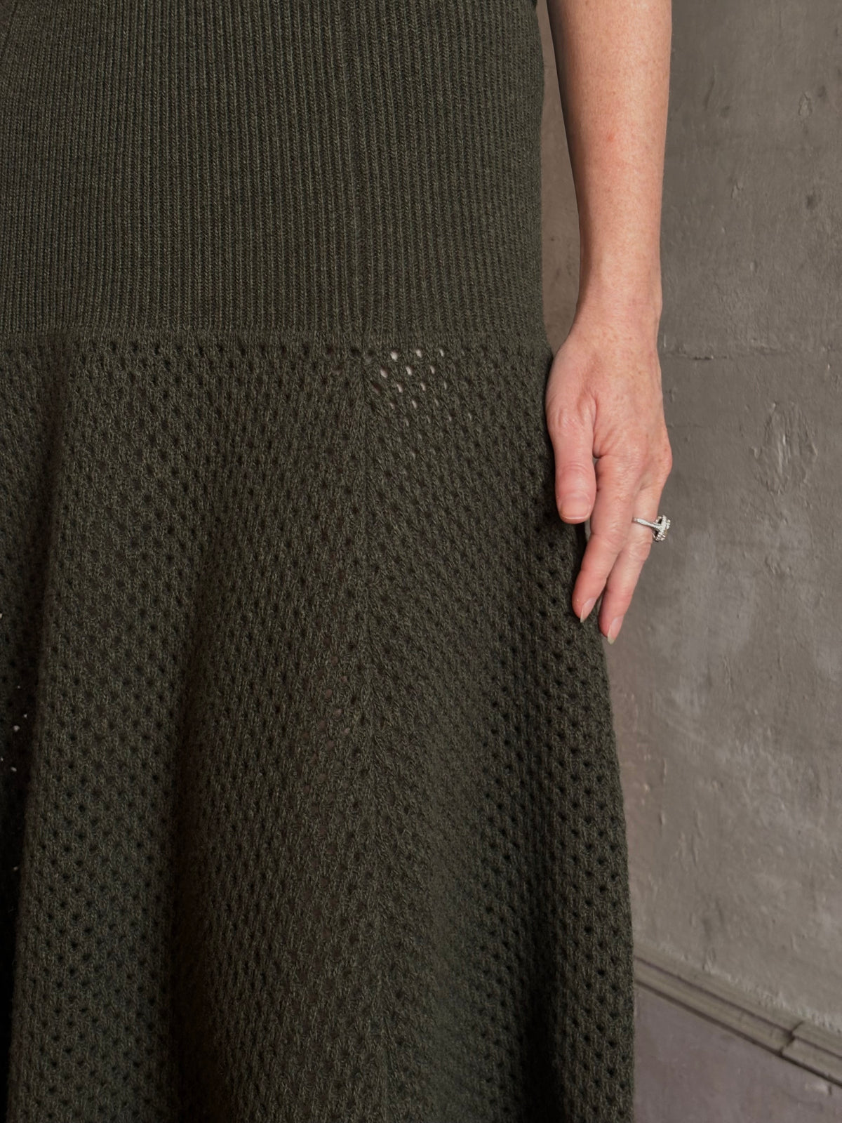 Mature woman wearing designer Ulla Johnson Lucia Wool dark green open Knit maxi Skirt with stretch waistband