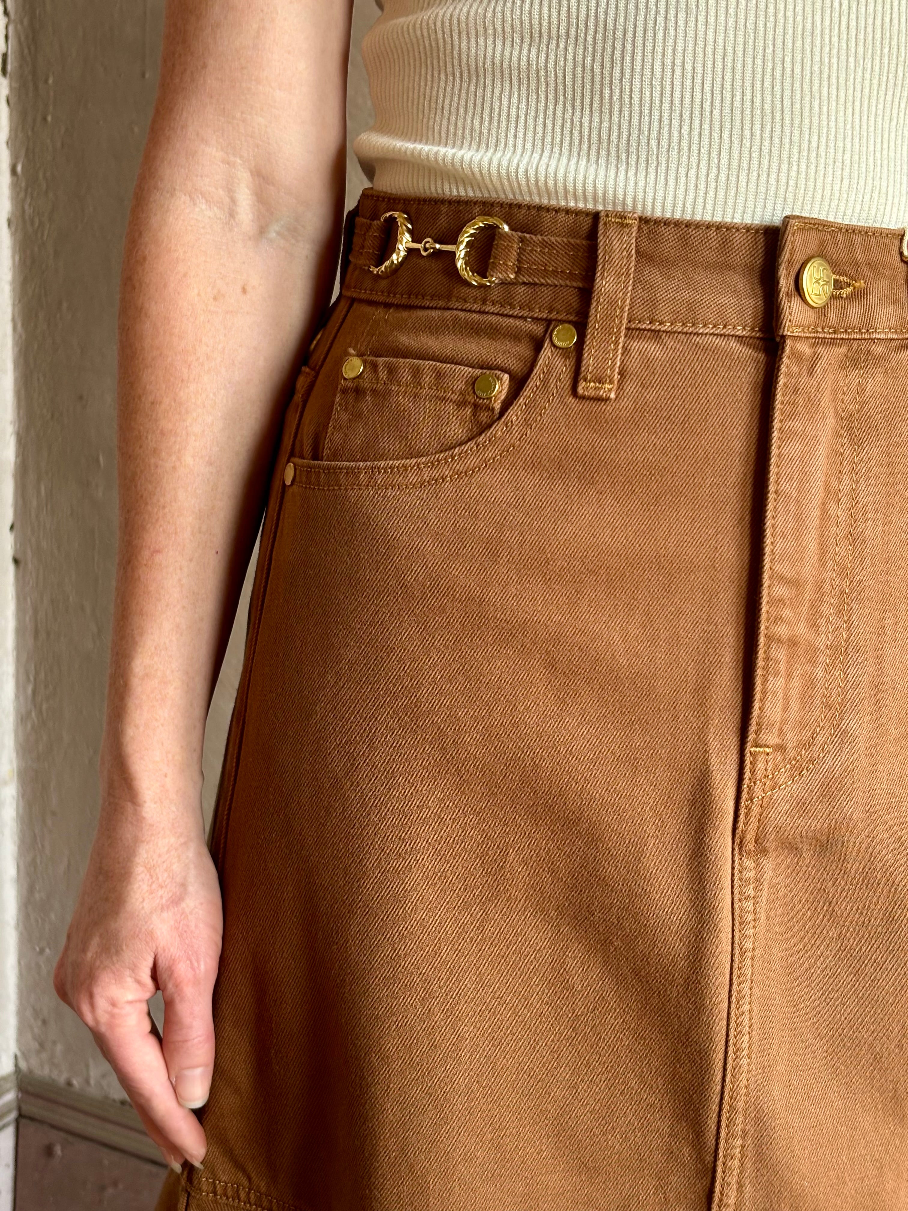 Mature woman wearing elevated designer Ulla Johnson Madelyn cotton denim skirt warm brown gold accents