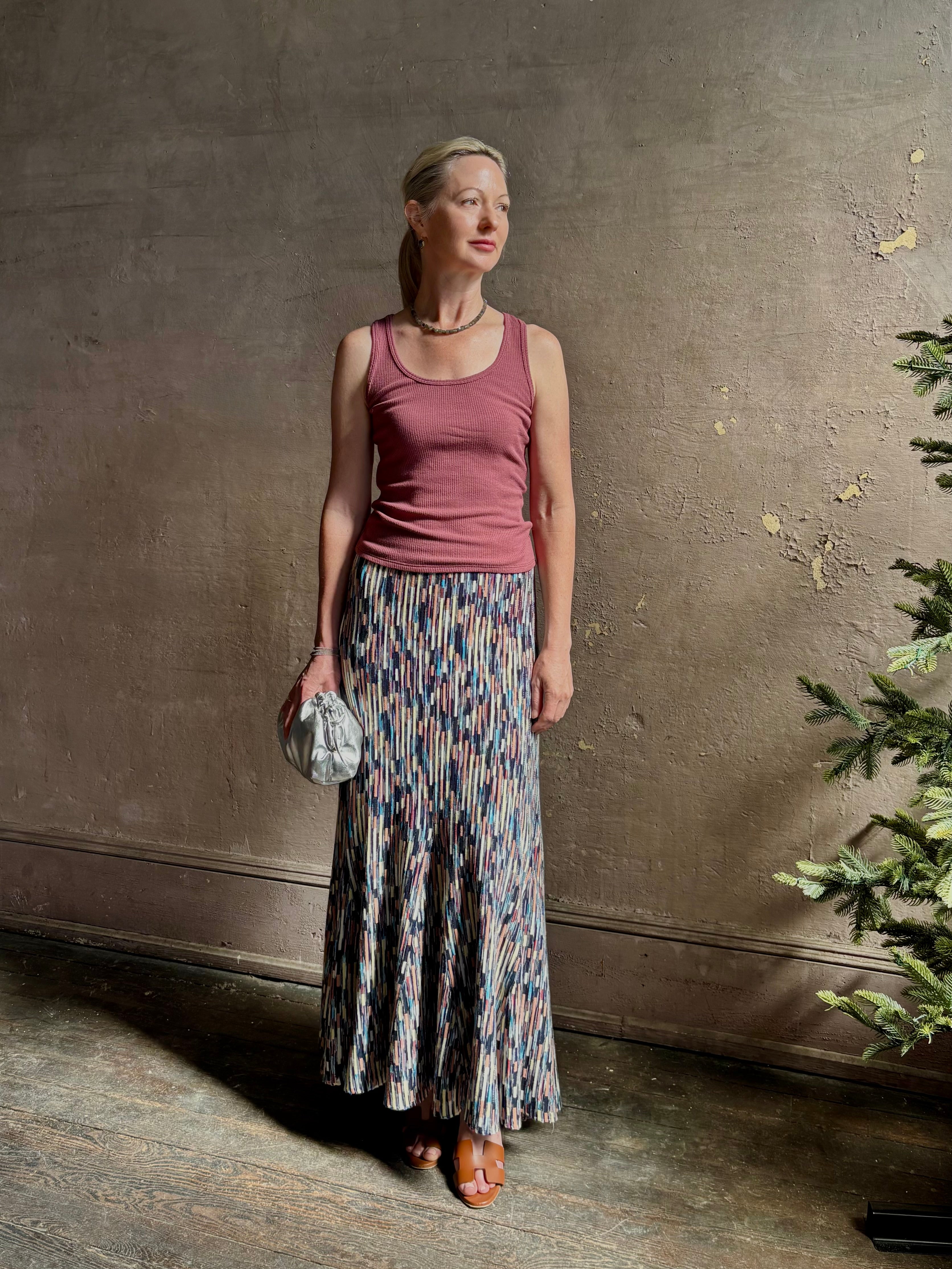 Mature woman wearing Ulla Johnson Marceline maxi knit cotton Skirt Oasis colorway navy,  aqua, and terra cotta