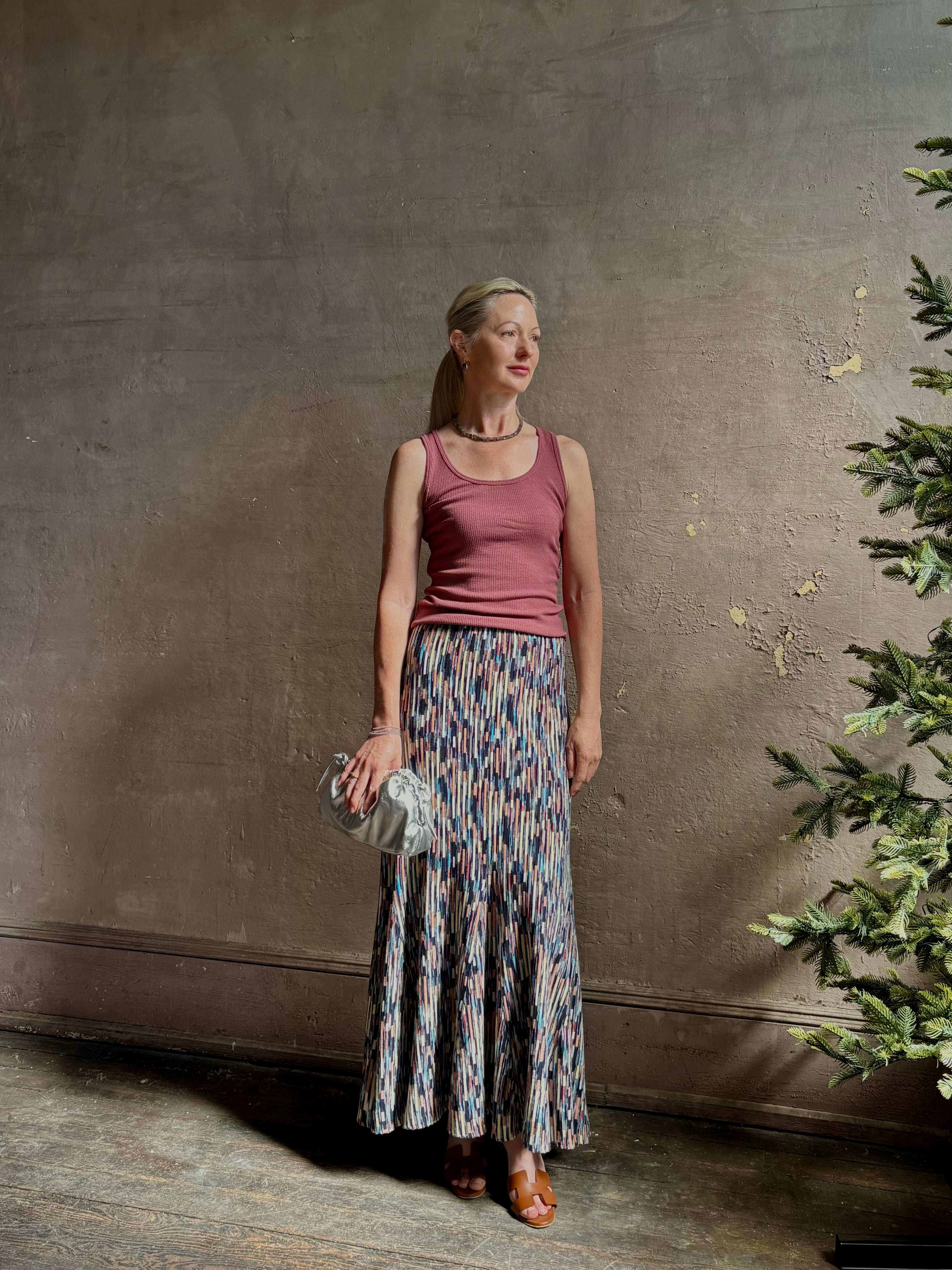 Mature woman wearing Ulla Johnson Marceline maxi knit cotton Skirt  Oasis colorway navy, cream, peach, yellow, 