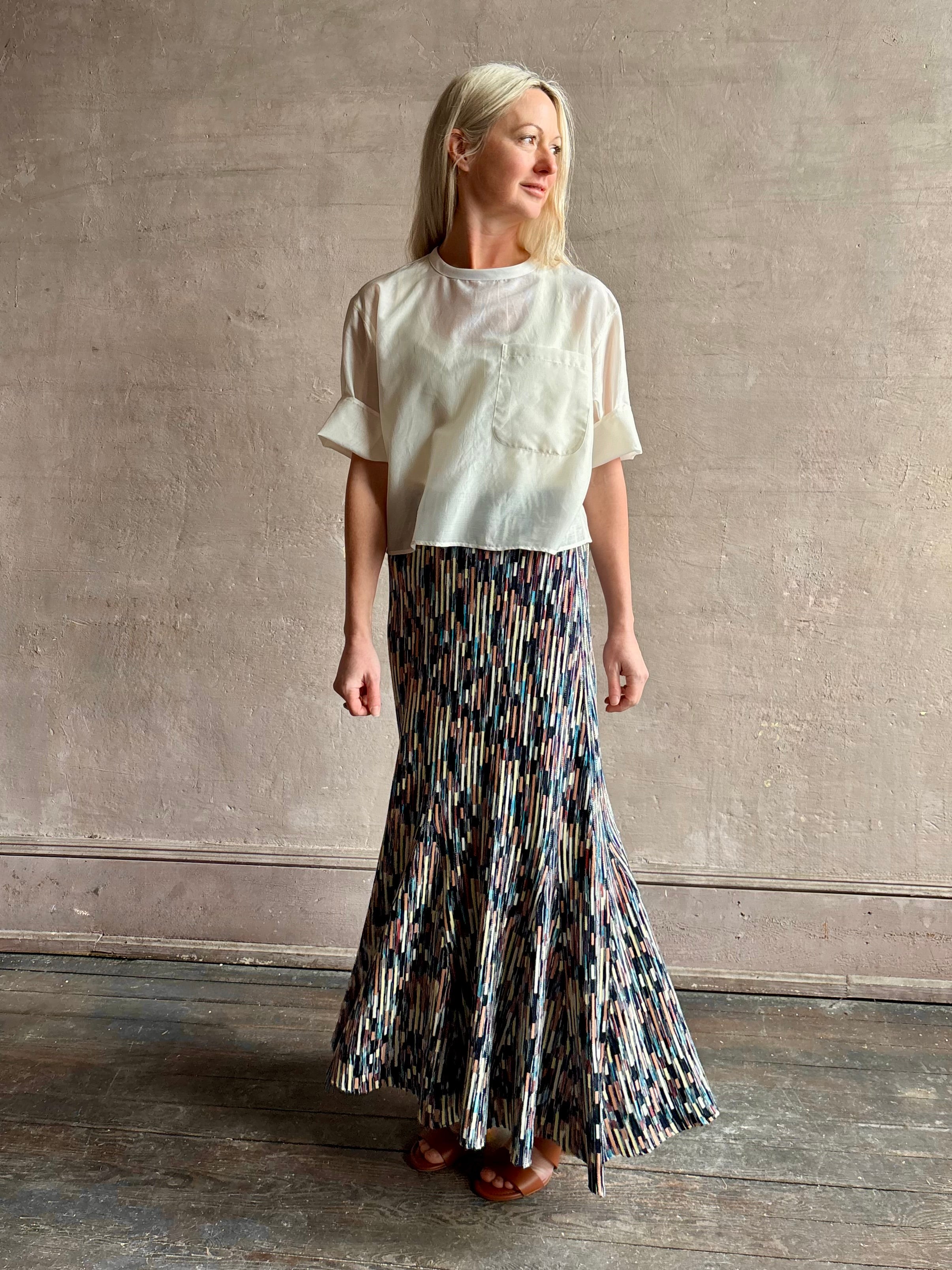 Mature woman wearing women's designer knit skirt Oasis colorway navy, cream, peach, yellow, aqua, and terra cotta