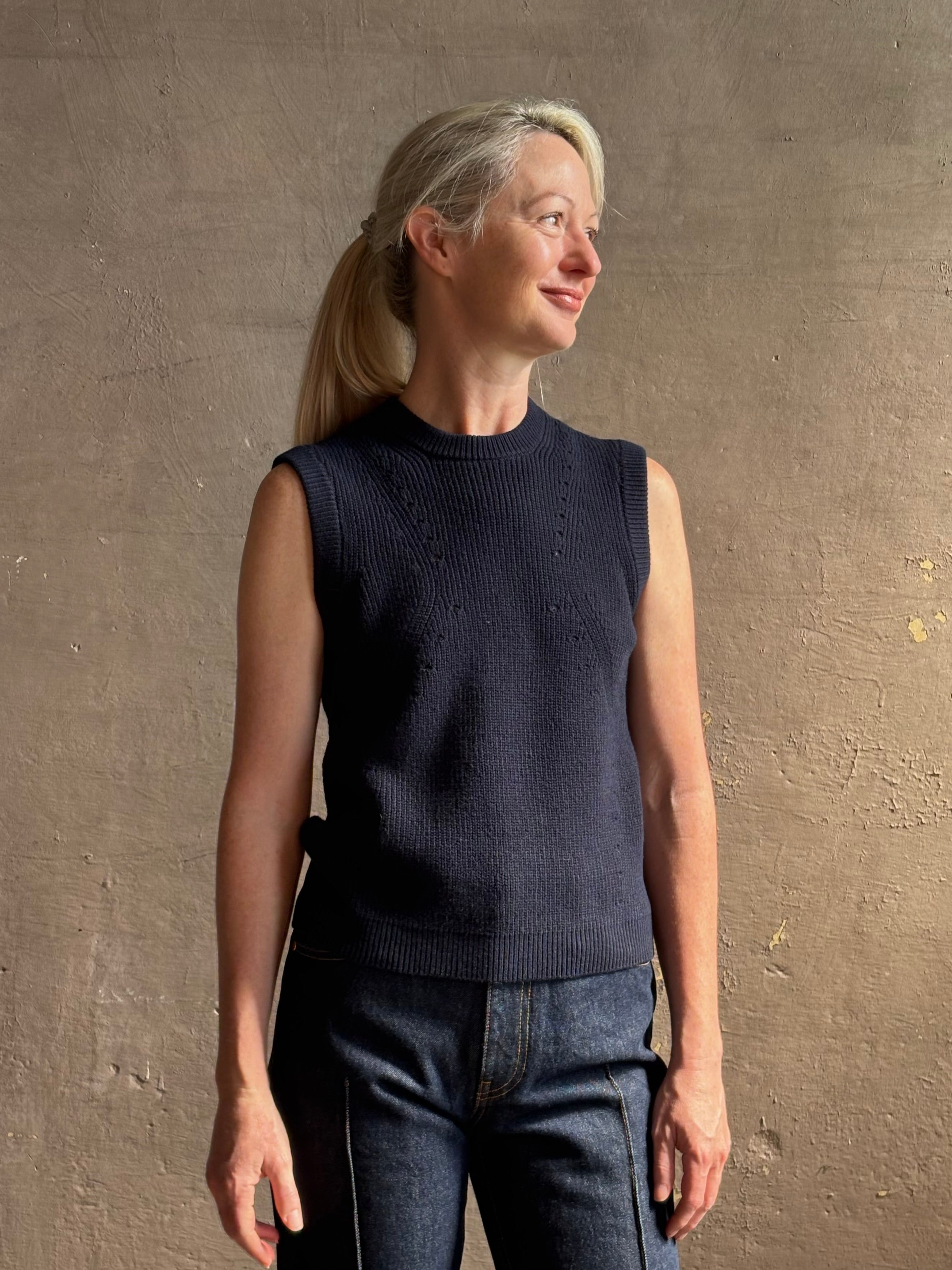 Mature woman wearing designer Margot sleeveless Knit Top from Ulla Johnson rendered in a rich midnight blue and knitted from 100% cotton with refined design details and a crew neckline