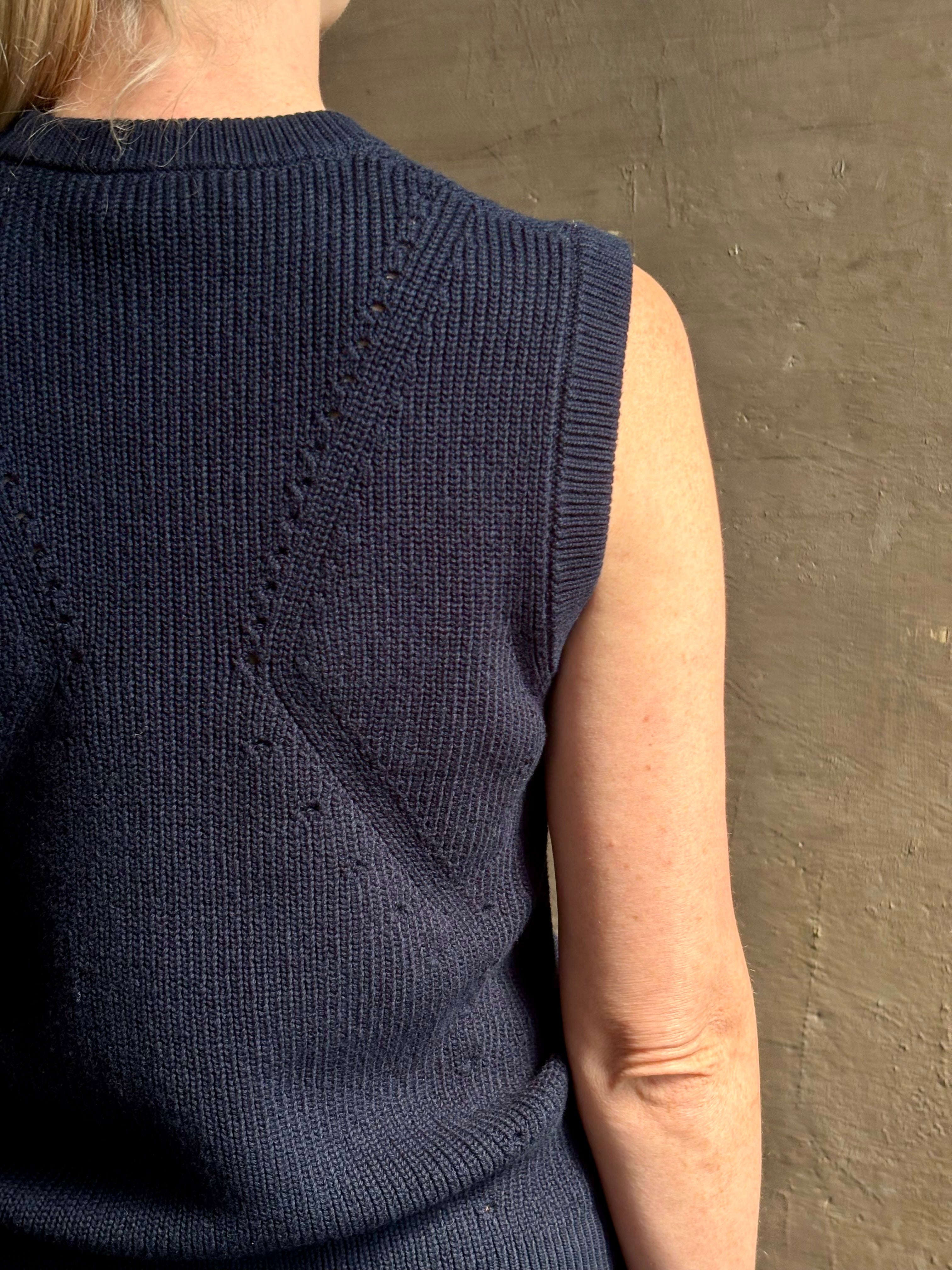 Mature woman wearing designer Margot sleeveless Knit Top from Ulla Johnson rendered in a rich midnight blue and knitted from 100% cotton with refined design details and a crew neckline for everyday sophistication