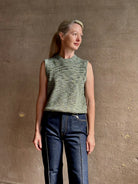 Mature model wearing Margot sleeveless Knit Top from Ulla Johnson rendered in a two tone heathered green and crafted from 100% cotton wth a crew neck and contrasting coral band at bottom