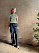 Mature model wearing Margot sleeveless Knit Top from Ulla Johnson rendered in a two tone heathered green and crafted from 100% cotton wth a crew neck and contrasting coral band at bottom