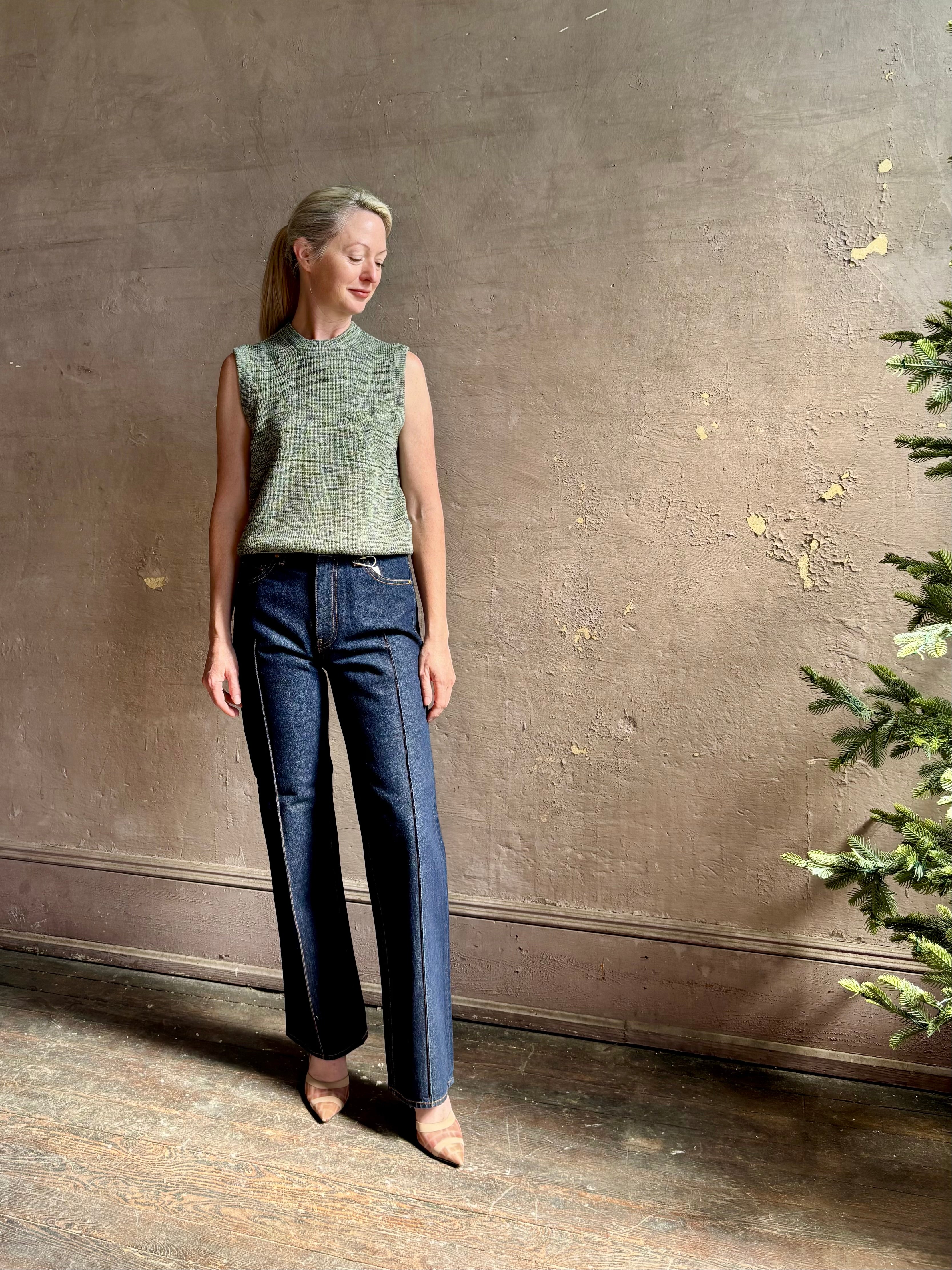 Mature model wearing Margot sleeveless Knit Top from Ulla Johnson rendered in a two tone heathered green and crafted from 100% cotton wth a crew neck and contrasting coral band at bottom