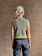Mature model wearing Margot sleeveless Knit Top from Ulla Johnson rendered in a two tone heathered green and crafted from 100% cotton wth a crew neck and contrasting coral band at bottom
