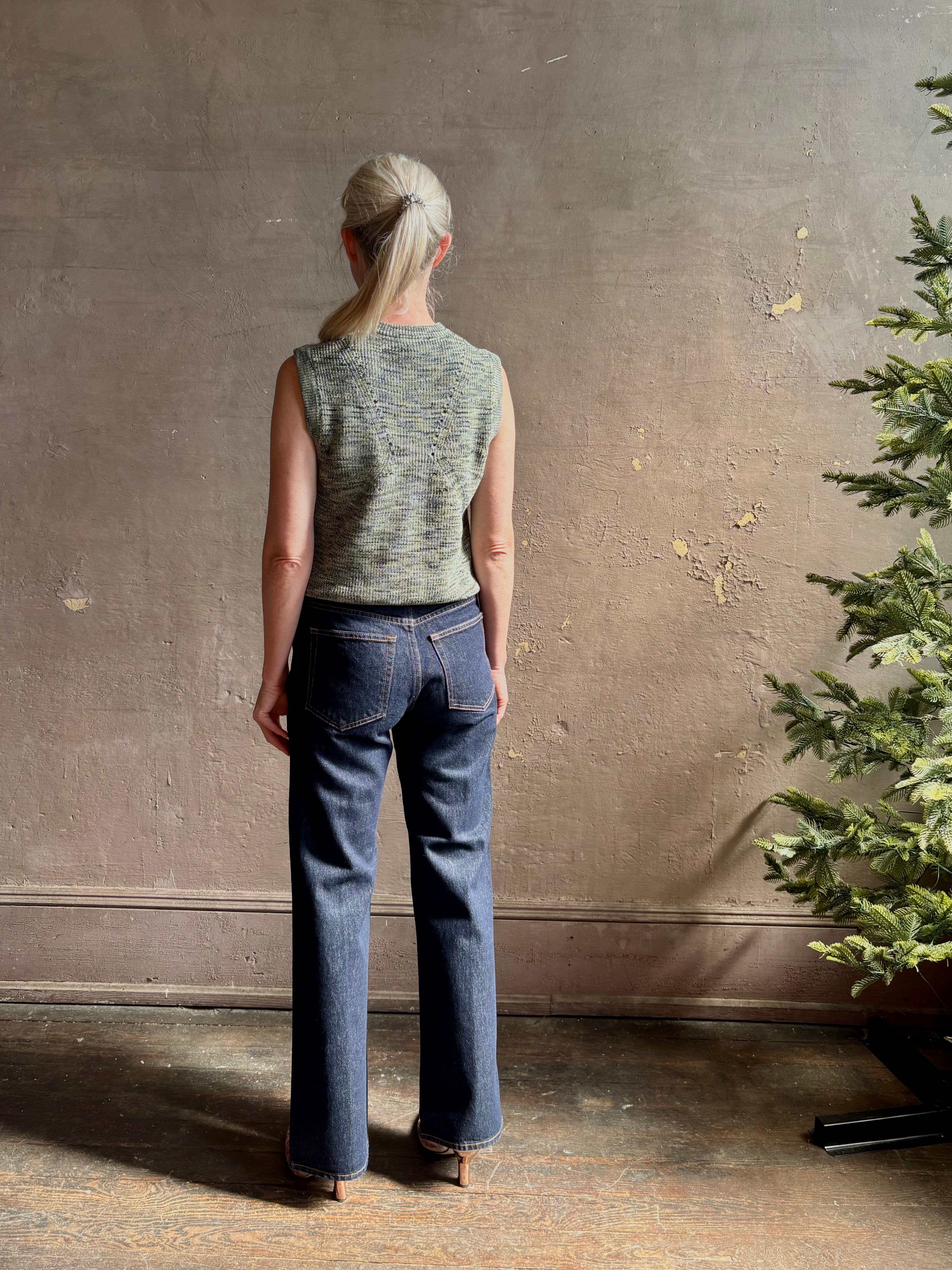 Mature model wearing Margot sleeveless Knit Top from Ulla Johnson rendered in a two tone heathered green and crafted from 100% cotton wth a crew neck and contrasting coral band at bottom