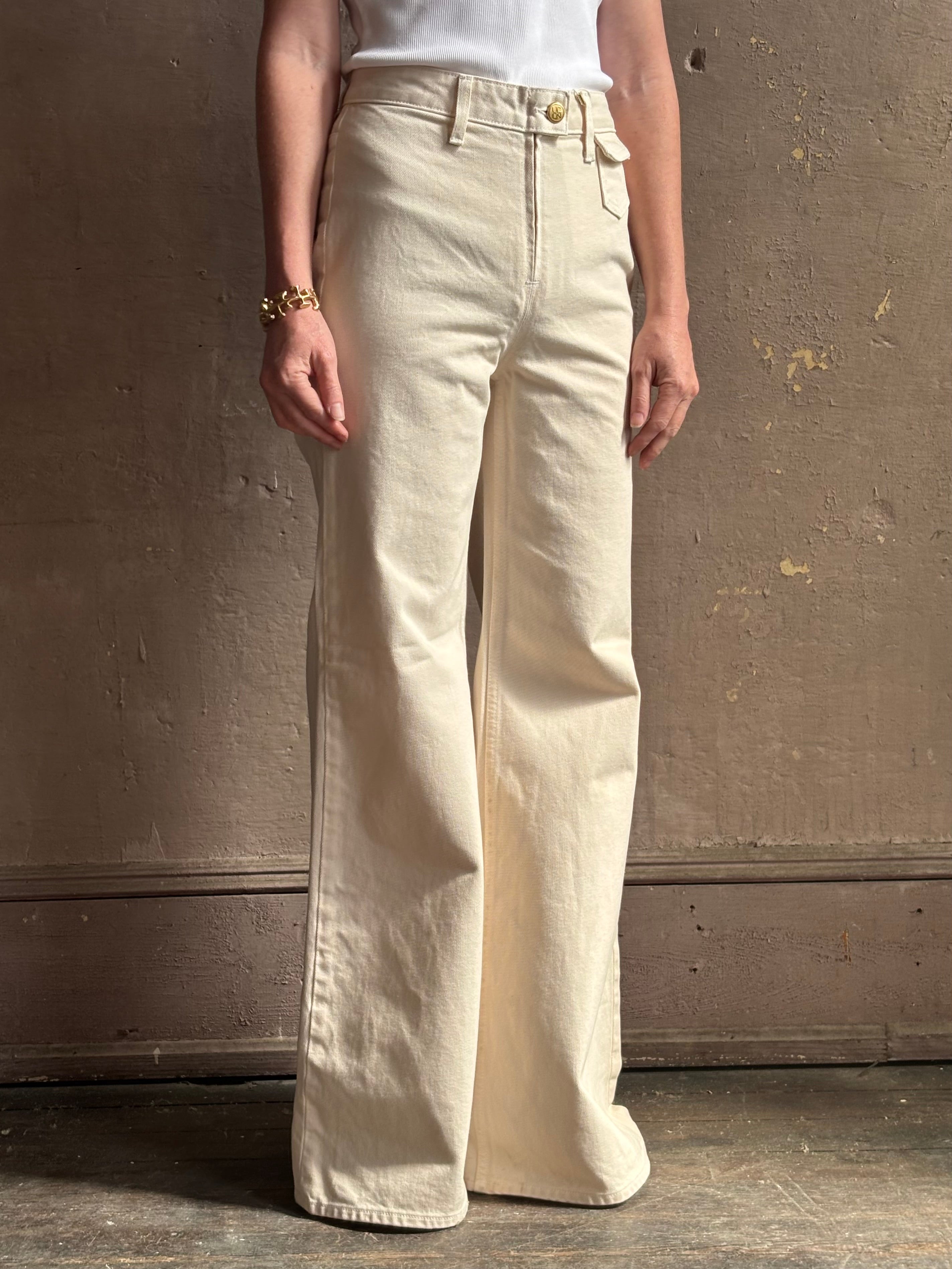 Woman wearing women's luxury designer denim by Ulla Johnson Odelia Jean handcrafted from 100% cotton in Los Angeles California with a high-rise and elegant slimmer wide leg