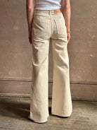 Woman wearing women's luxury designer denim by Ulla Johnson Odelia Jean handcrafted from 100% cotton in Los Angeles California with a high-rise and elegant slimmer wide leg