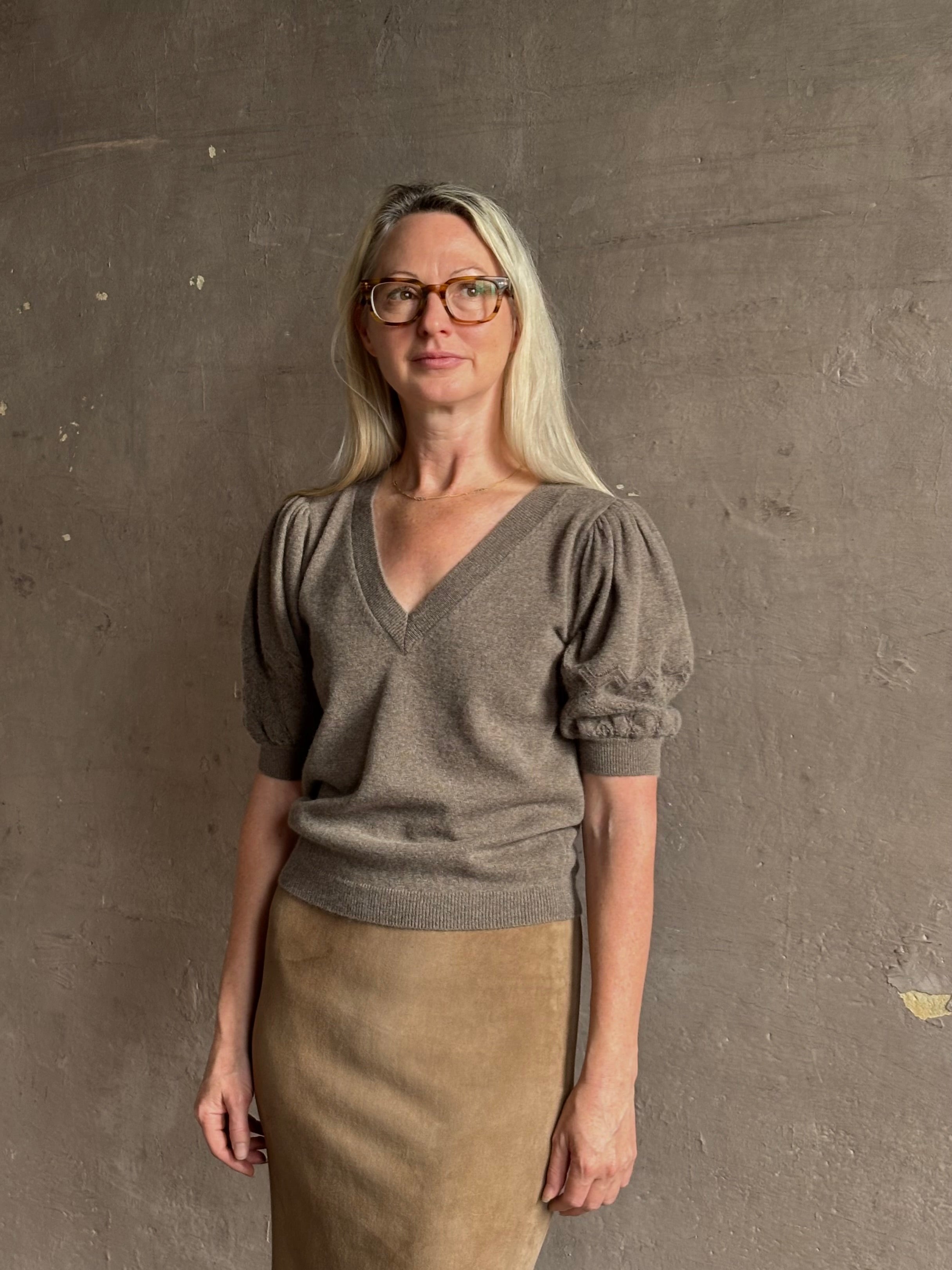 Mature woman wearing Ulla Johnson Reina v-neck driftwood brown short sleeve iIntricate Woven Sleeve Detail