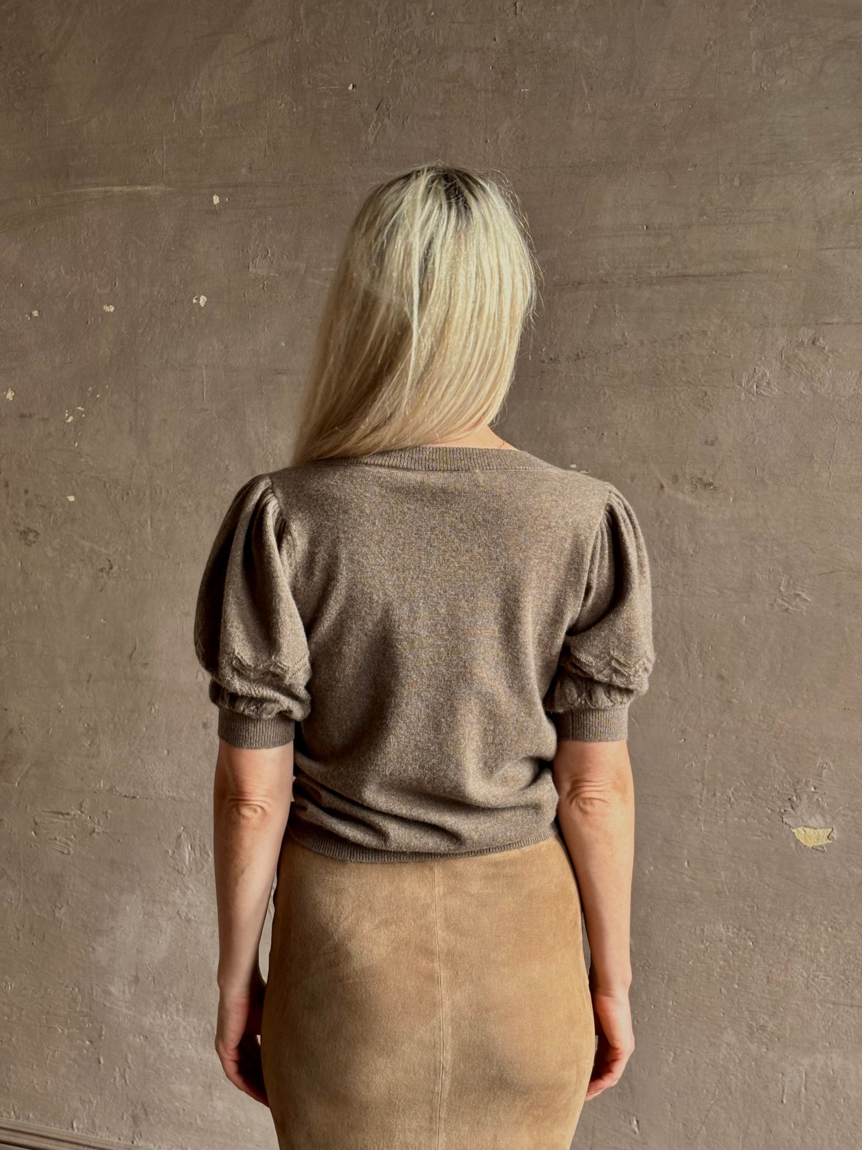 Mature woman wearing Ulla Johnson Reina v-neck driftwood brown short sleeve iIntricate Woven Sleeve Detail