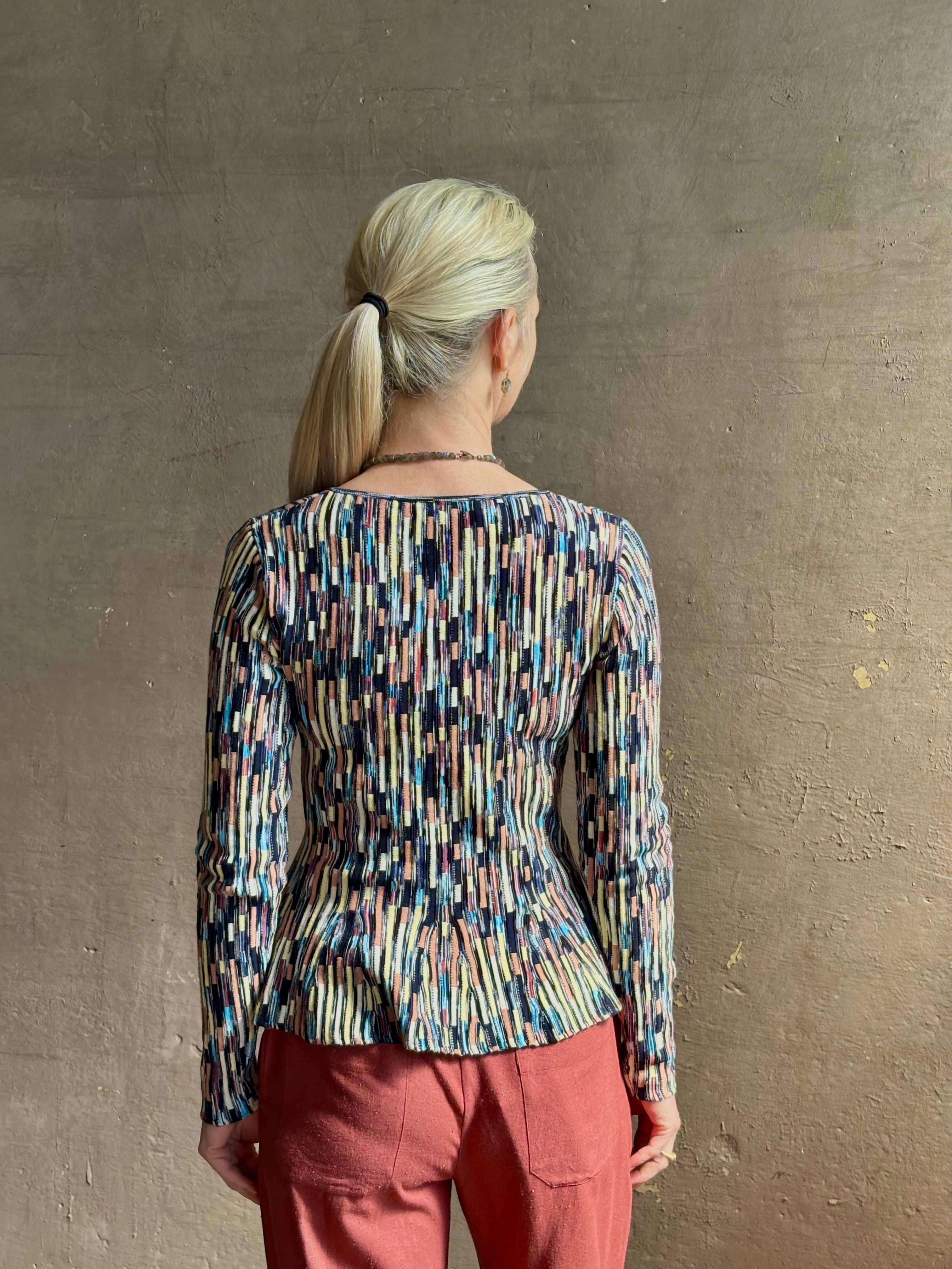 Mature woman wearing premium cotton ULLA JOHNSON Rosalia Peplum Knit Top Oasis long sleeves v-neck