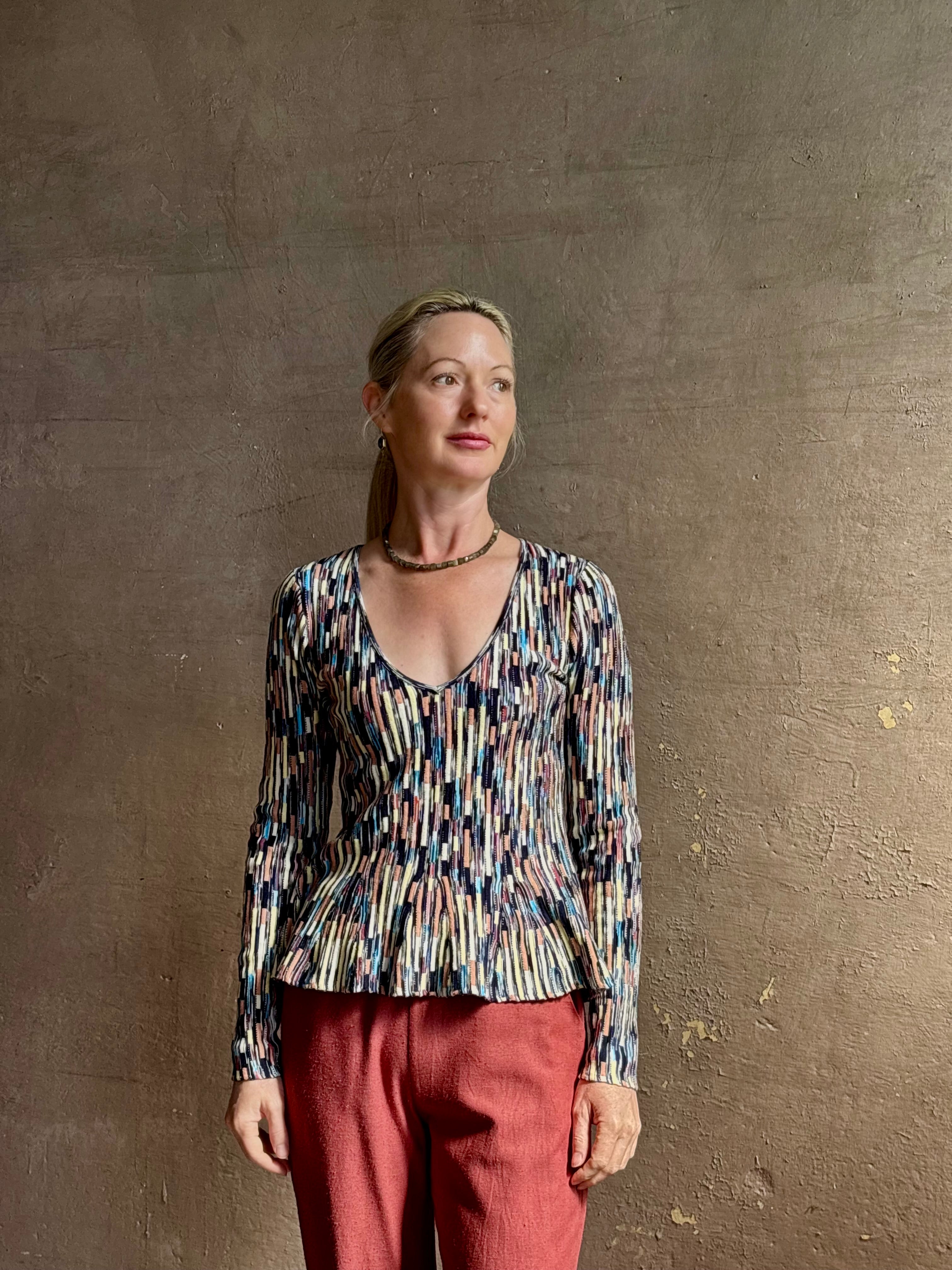 Mature woman wearing premium cotton ULLA JOHNSON Rosalia Peplum Knit Top Oasis long sleeves v-neck